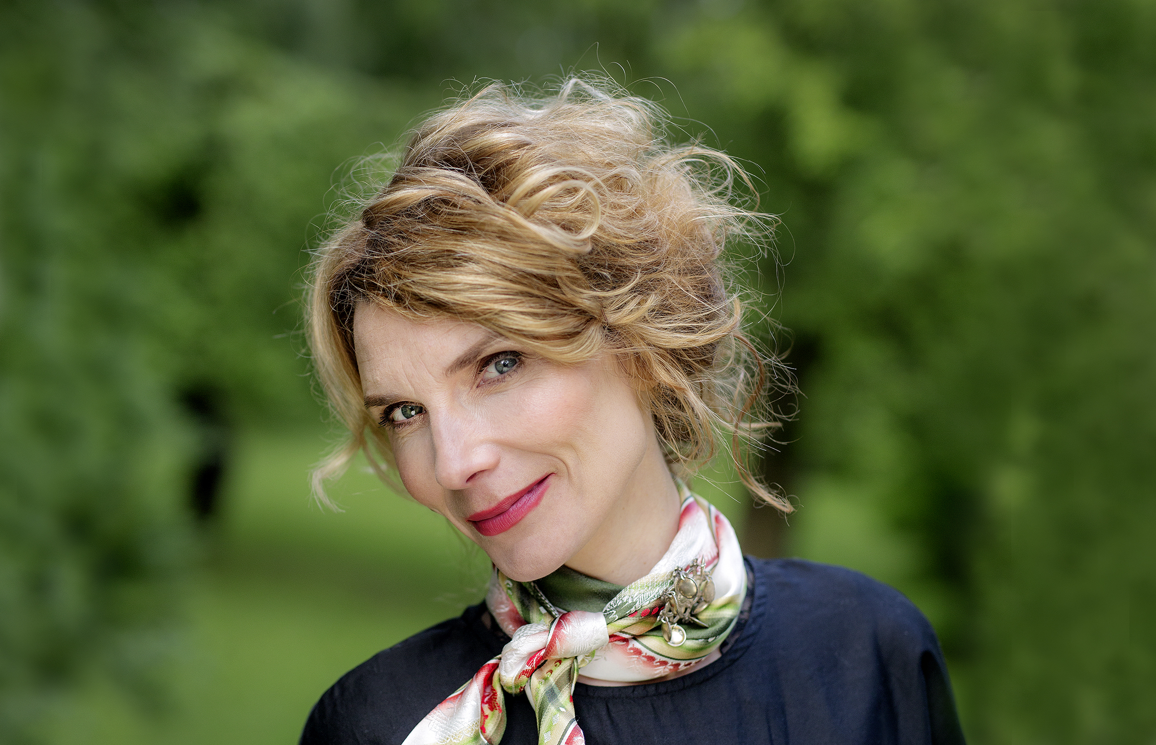 Et nærportrett av Herborg Kråkevik. Hun har hodet på skakke og smiler til fotografen. Hun har et tynt skjerf knytt rundt halsen.