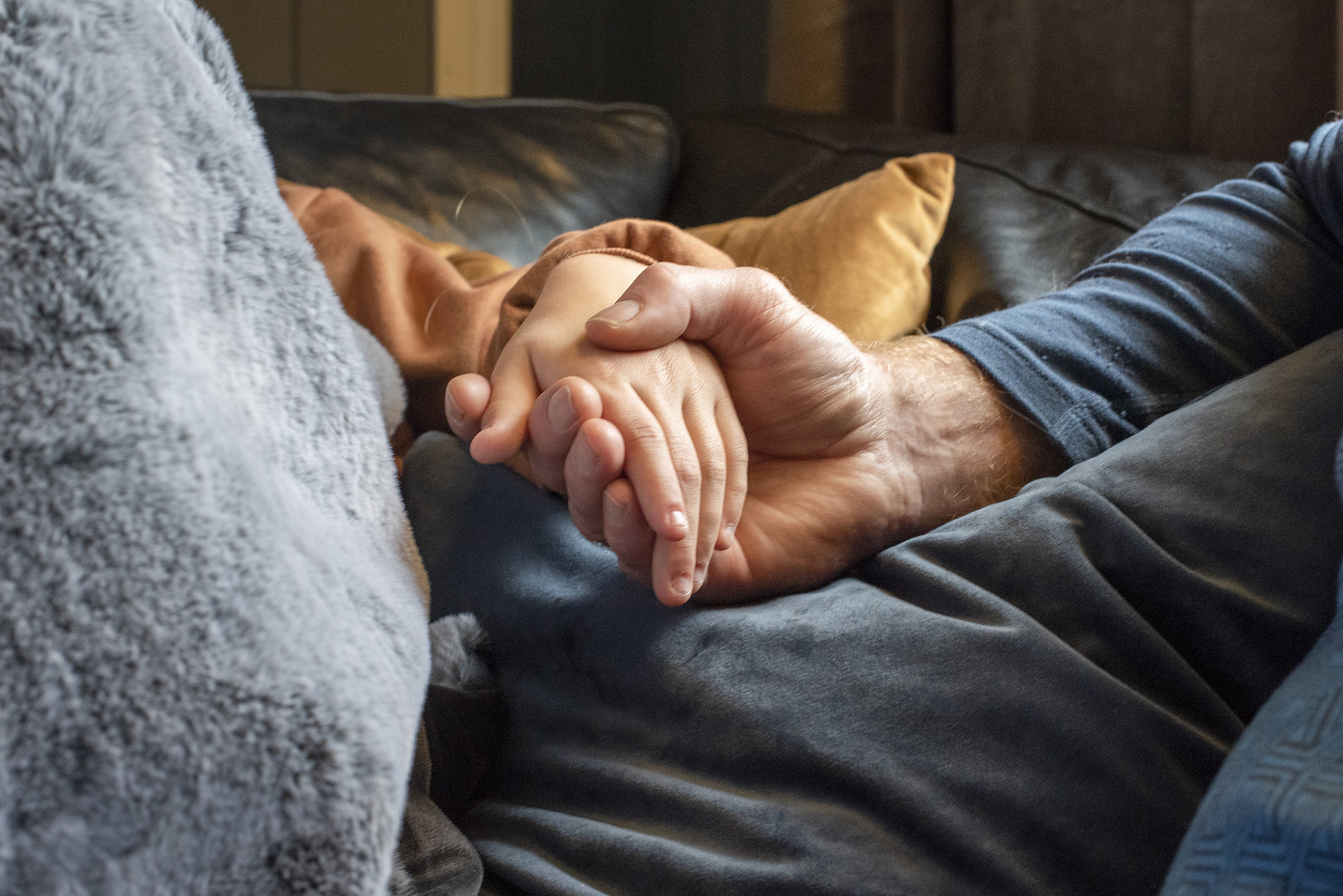 En voksen hånd holder en barnehånd