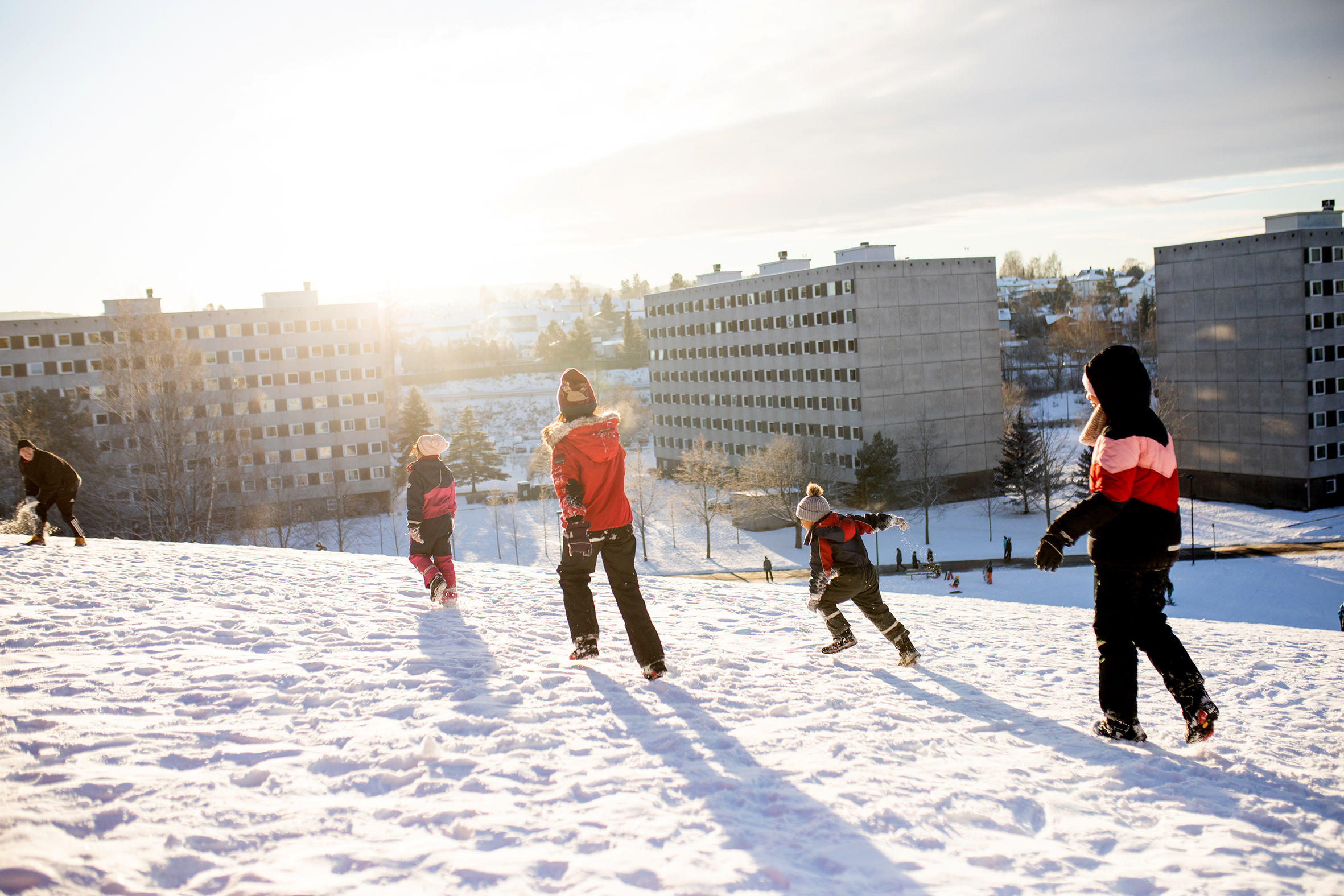 Barn leker i snøen blant blokkene på Haugenstua