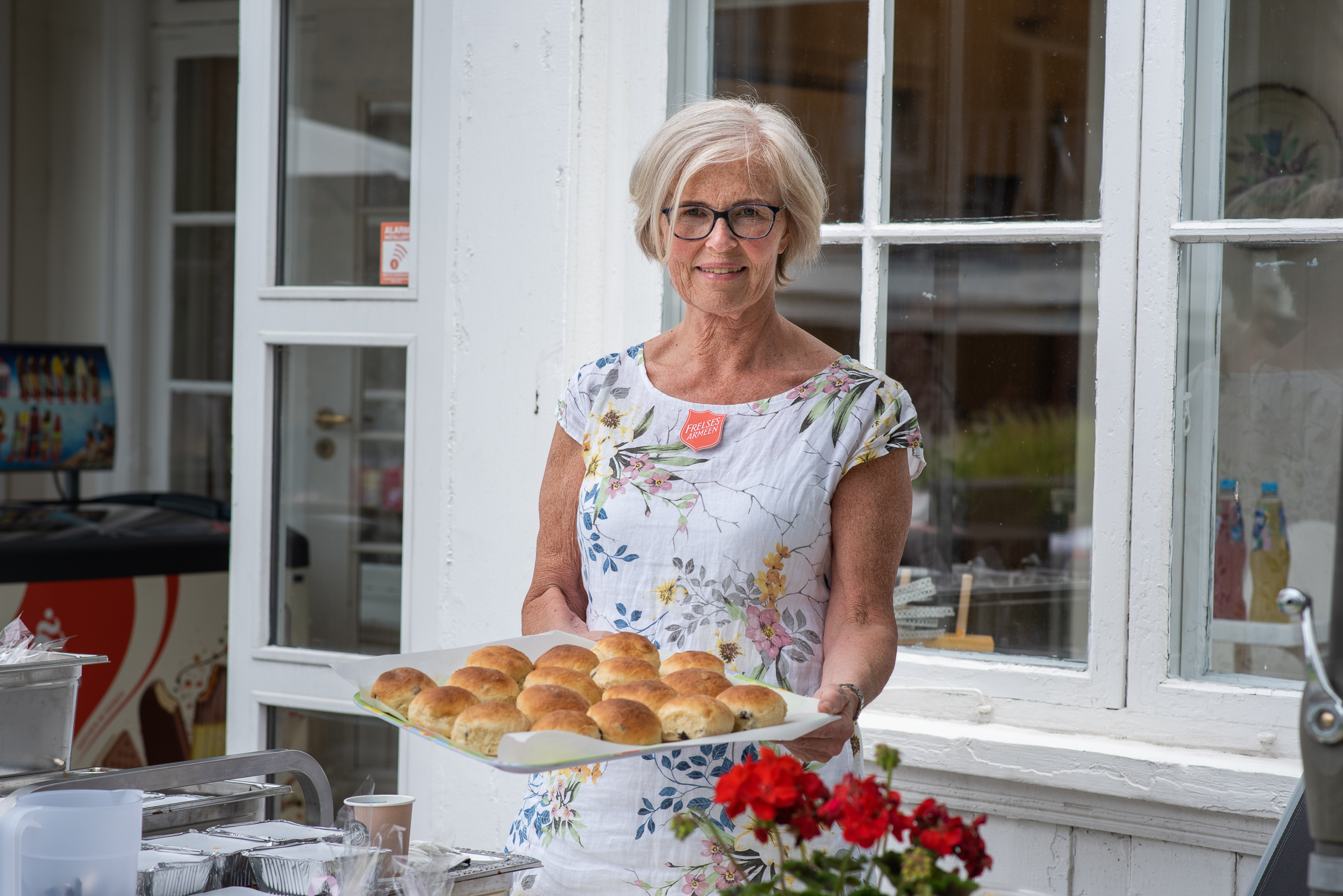 Solfrid Slettholm holder et fat med boller ute på terrassen