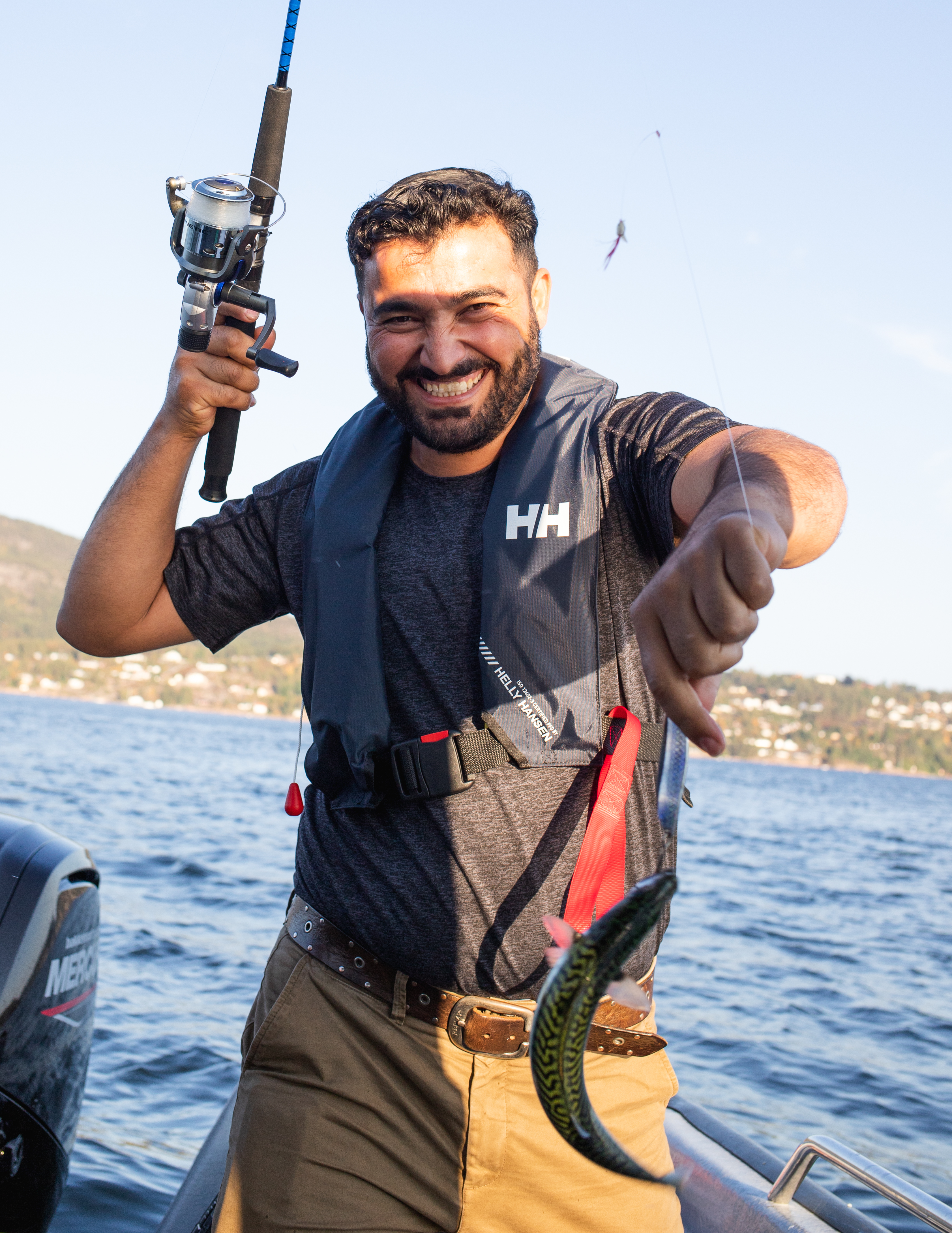 Deltagerne drar opp fisk med fiskestang fra båten