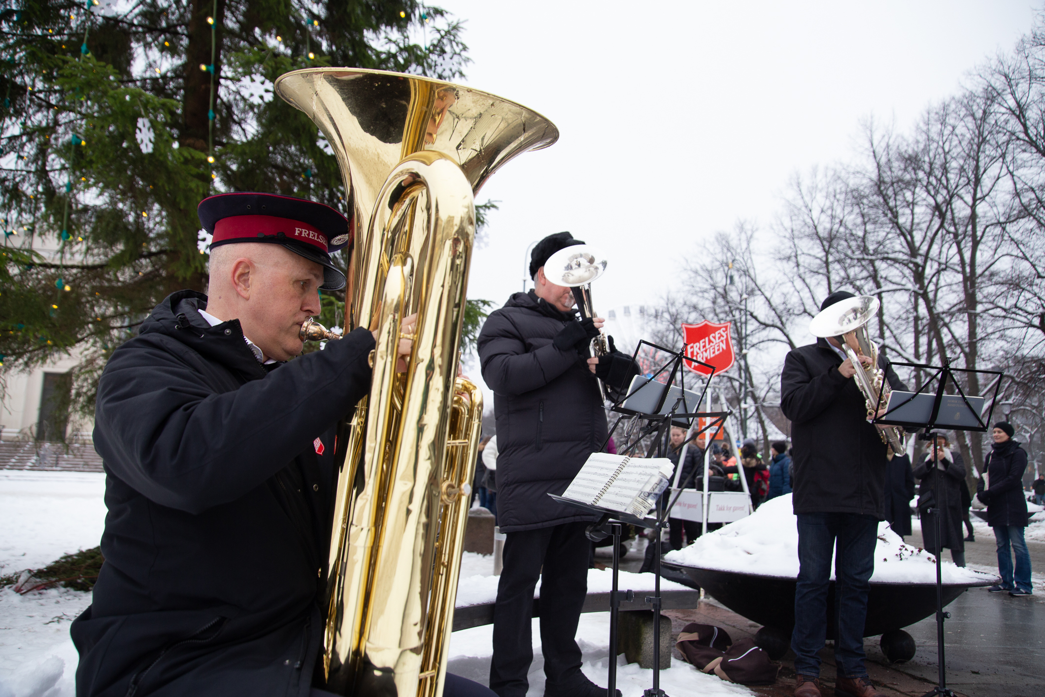 Tre musikanter fra Frelsesarmeen med ulike brassinstrumenter.