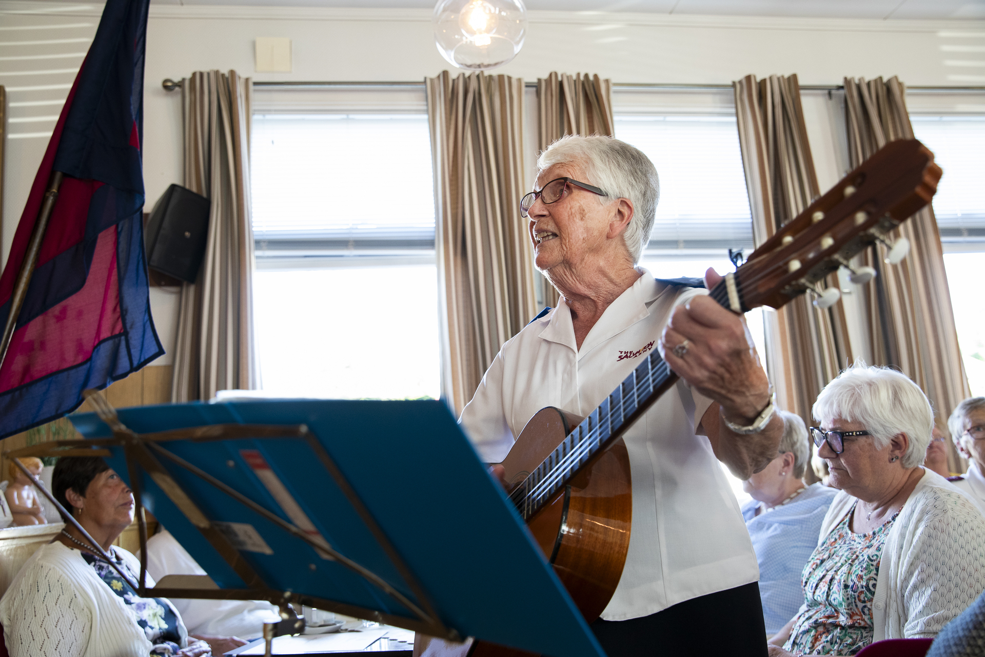 Kvinne spiller gitar på et møte.