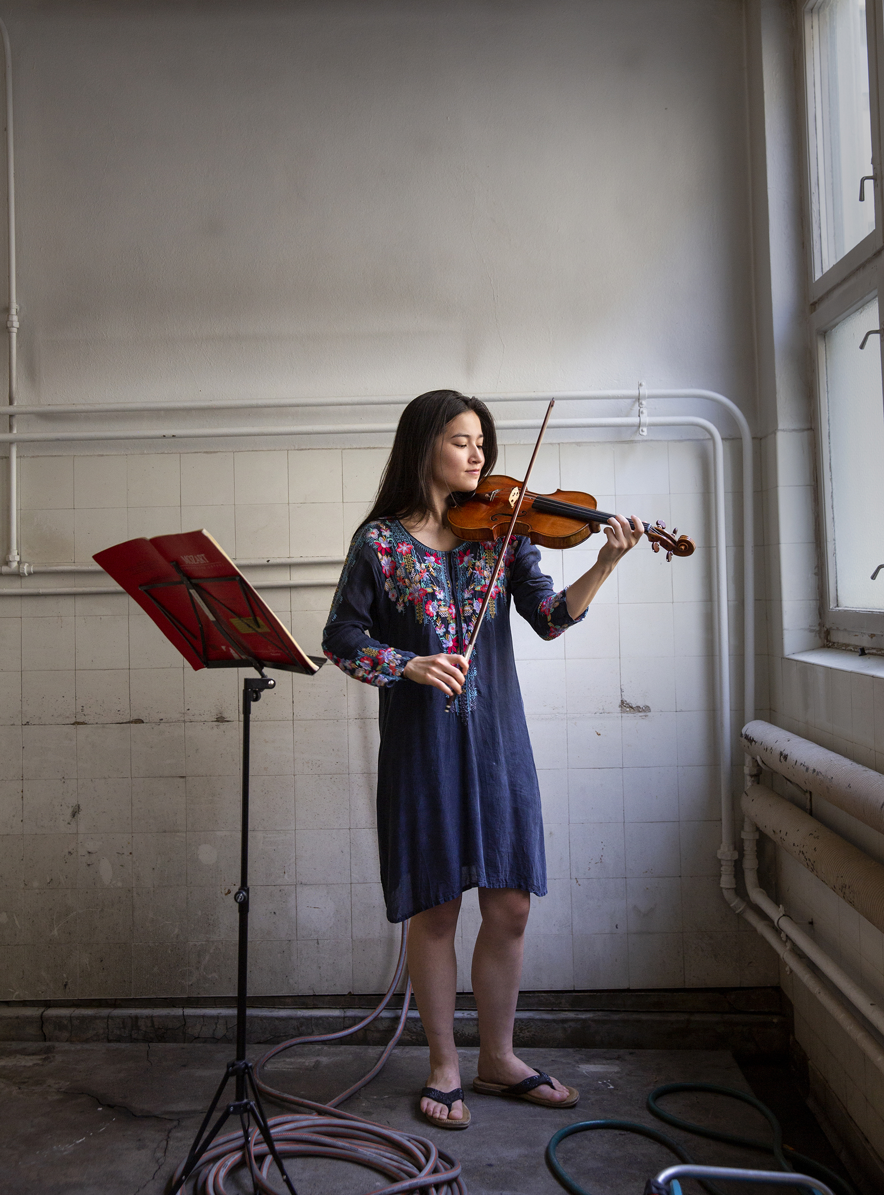 Ina øver på fiolin i blokkas vaskekjeller