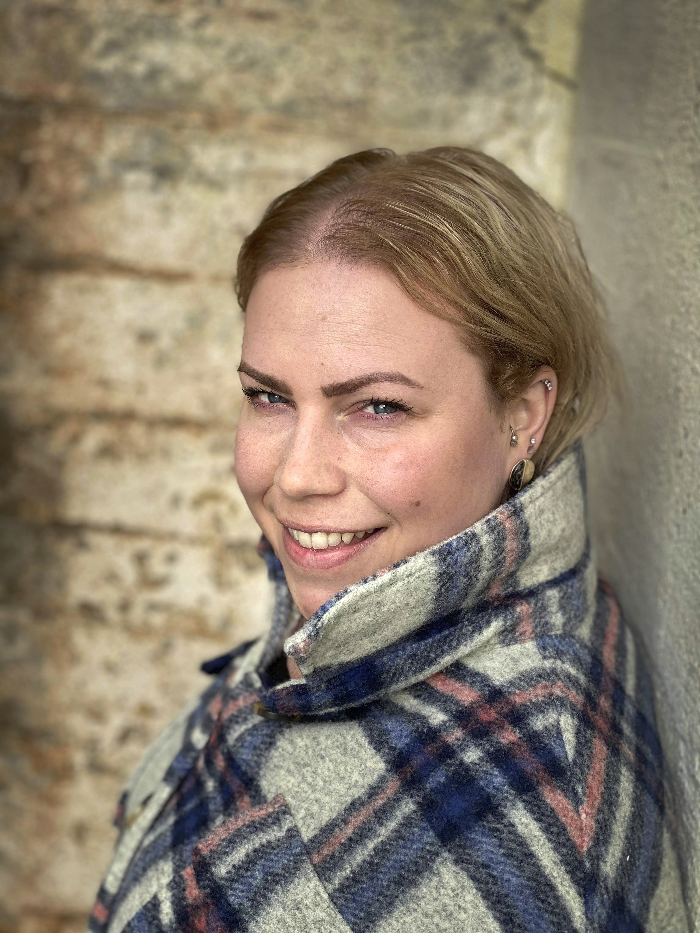 Ingebjørg Andrea Ådnanes er blond med blå øyne og har på seg en går og blå rutete skjorte