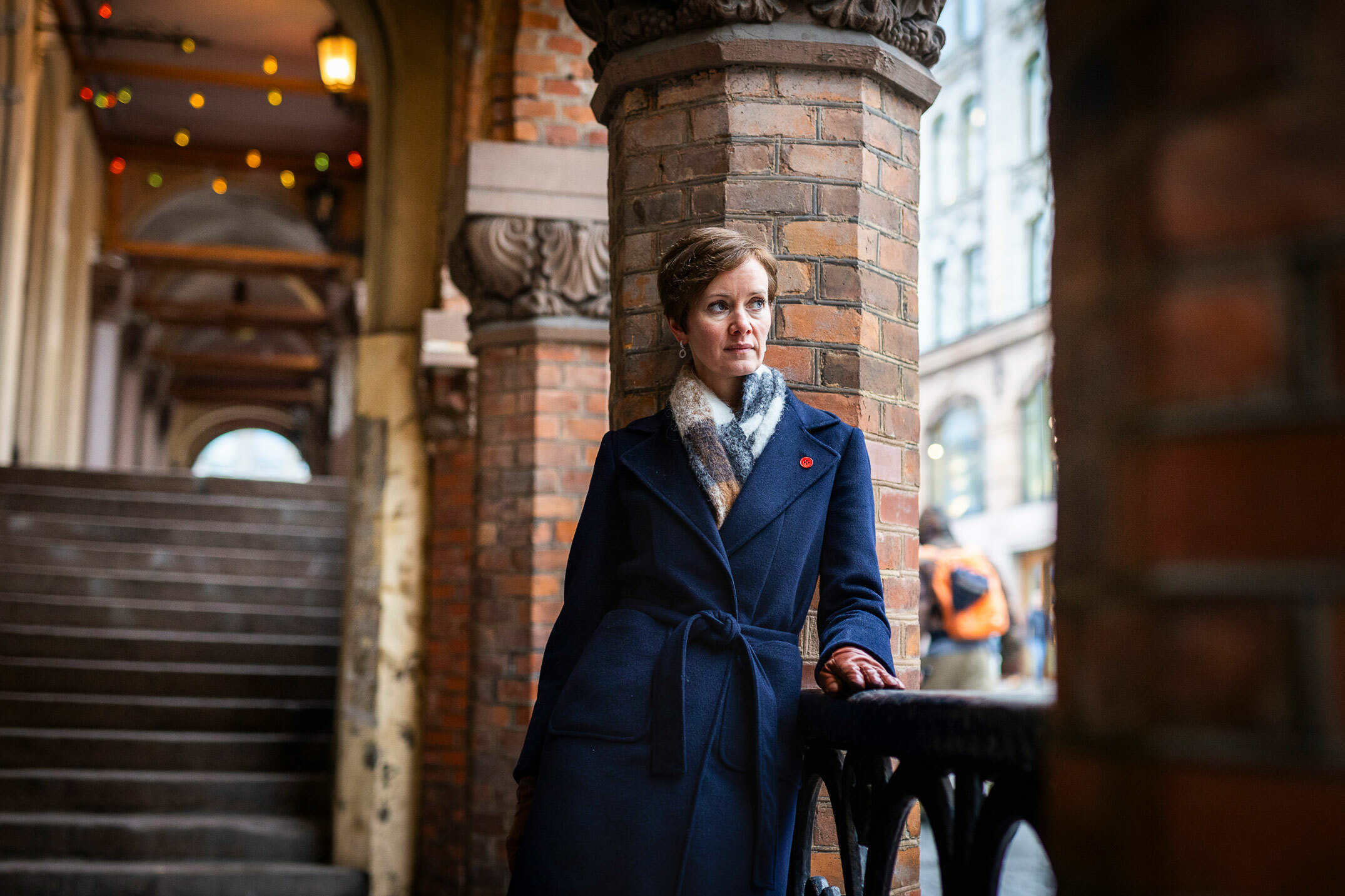 Foto: Samme kvinne i blå kåpe med rød knapp.