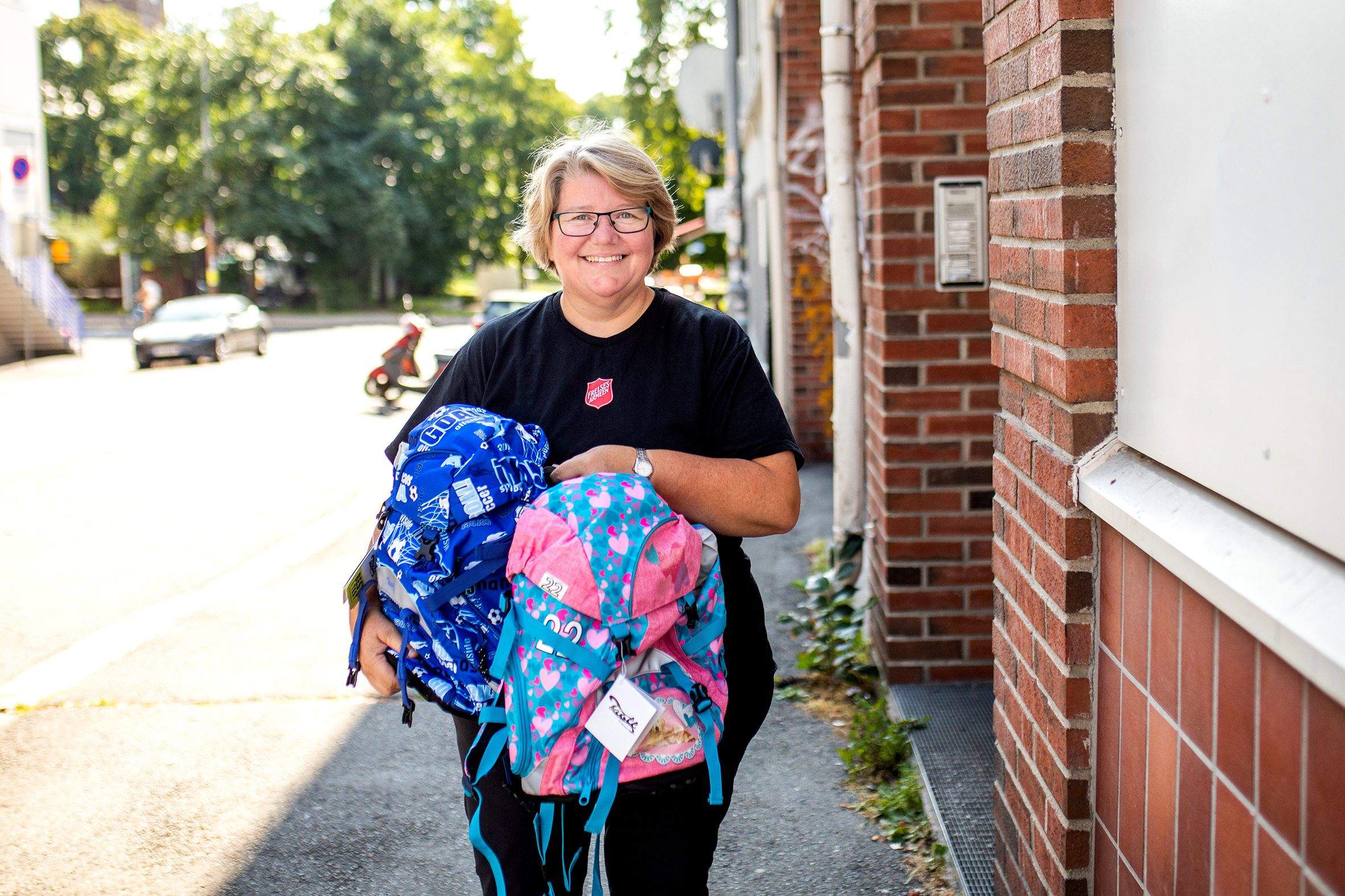 Iren Mathisen bærer på nye skolesekker med skrivesaker til skolestart