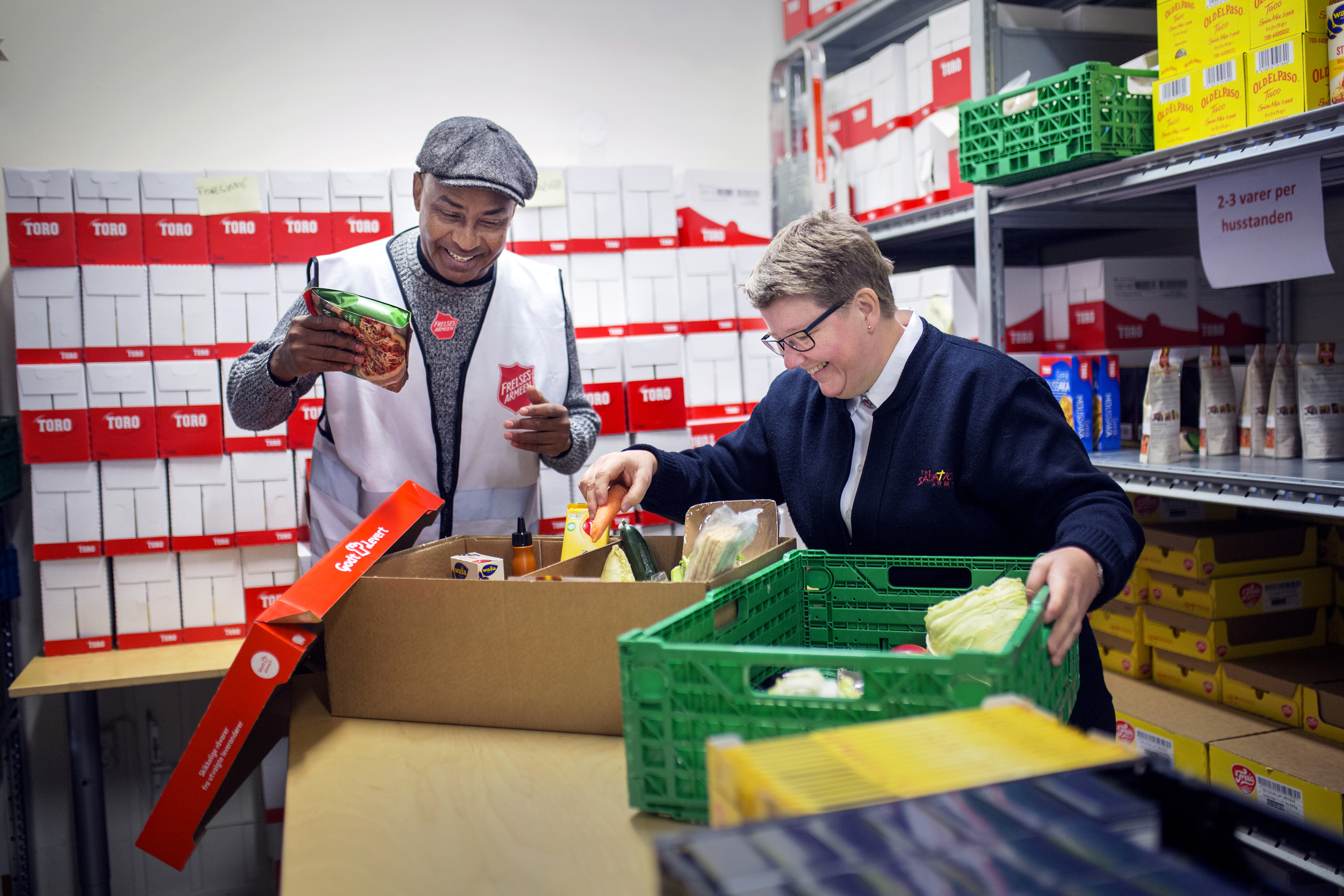 Irene pakker mat sammen med en av de frivillige.