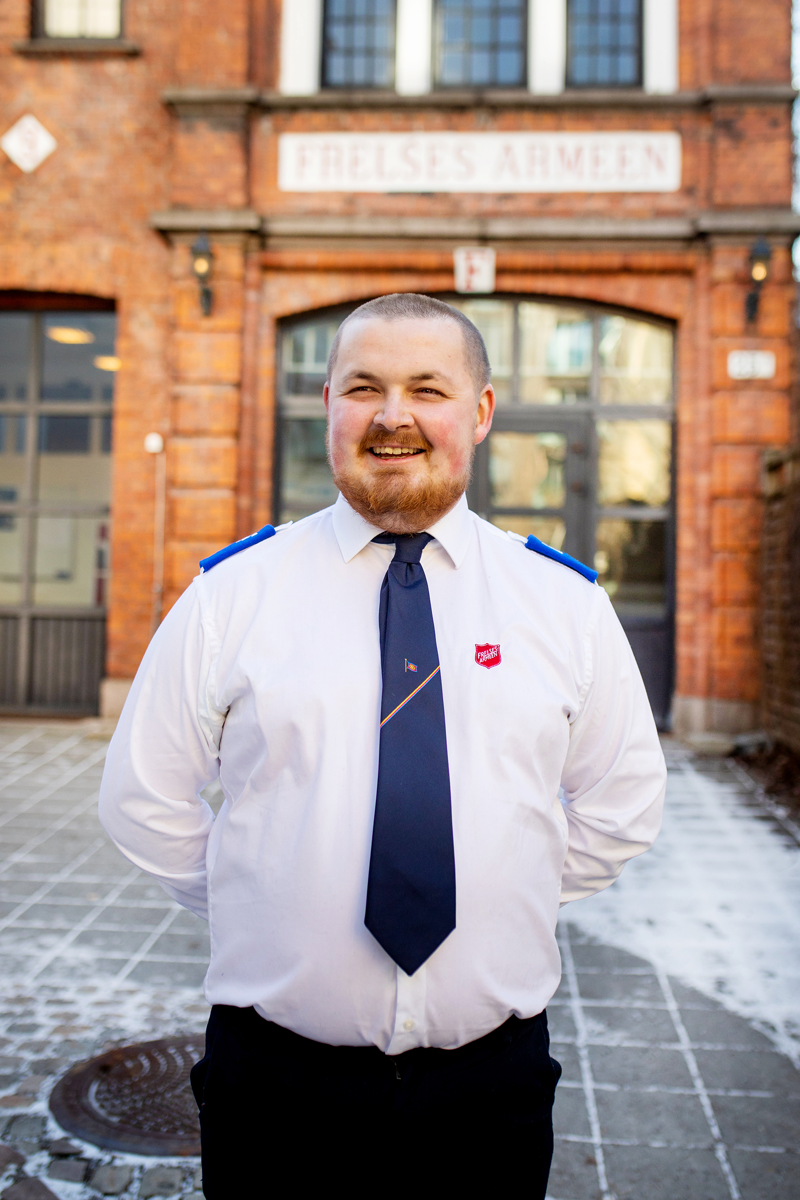 Jørgen Johnsen i Frelsesarmee uniform utenfor Frelsesarmeen på Grynerløkka i Oslo (bildet t.v.) Utstrakt vottene i gult og rødt (bildet t.h.)