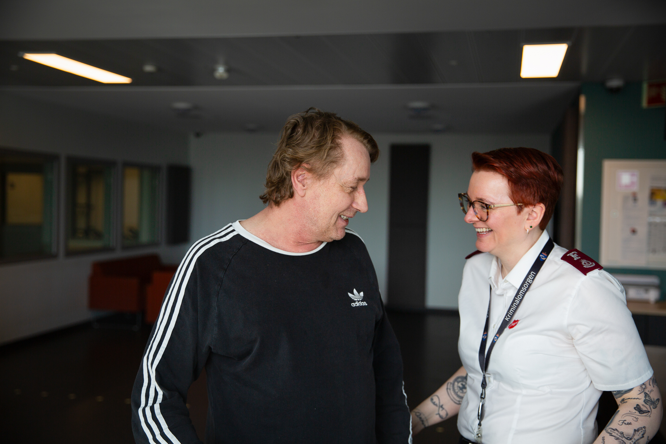 En middelaldrende mann med blå genser står sammen med en kvinne i hvit frelsesarméskjorte. Begge smiler.