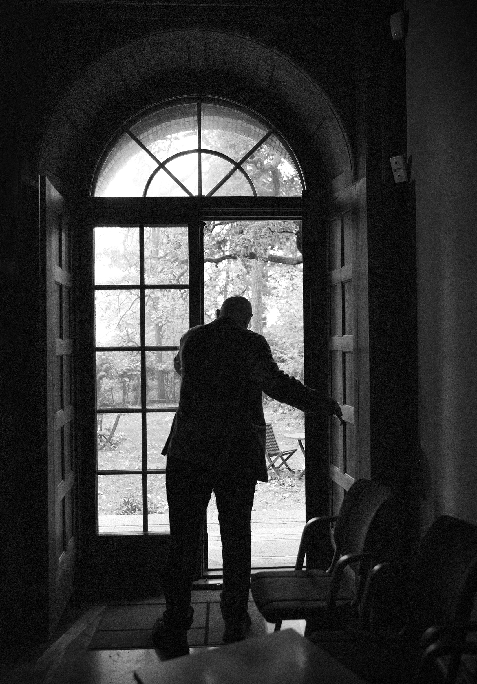 Bildet viser Johannessen på vei ut en glassdør, med ryggen mot kamera.