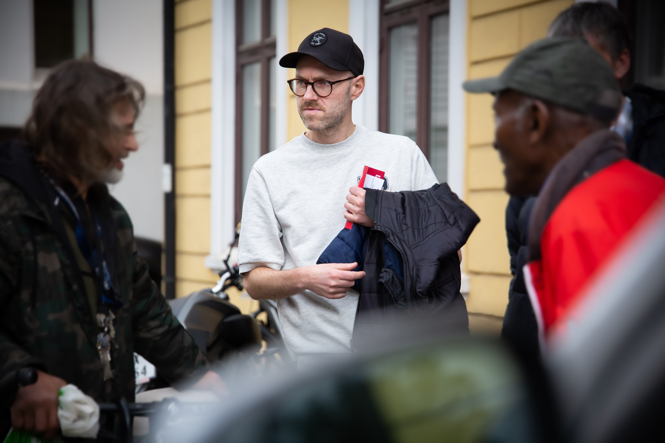 Tre menn snakker sammen på gaten