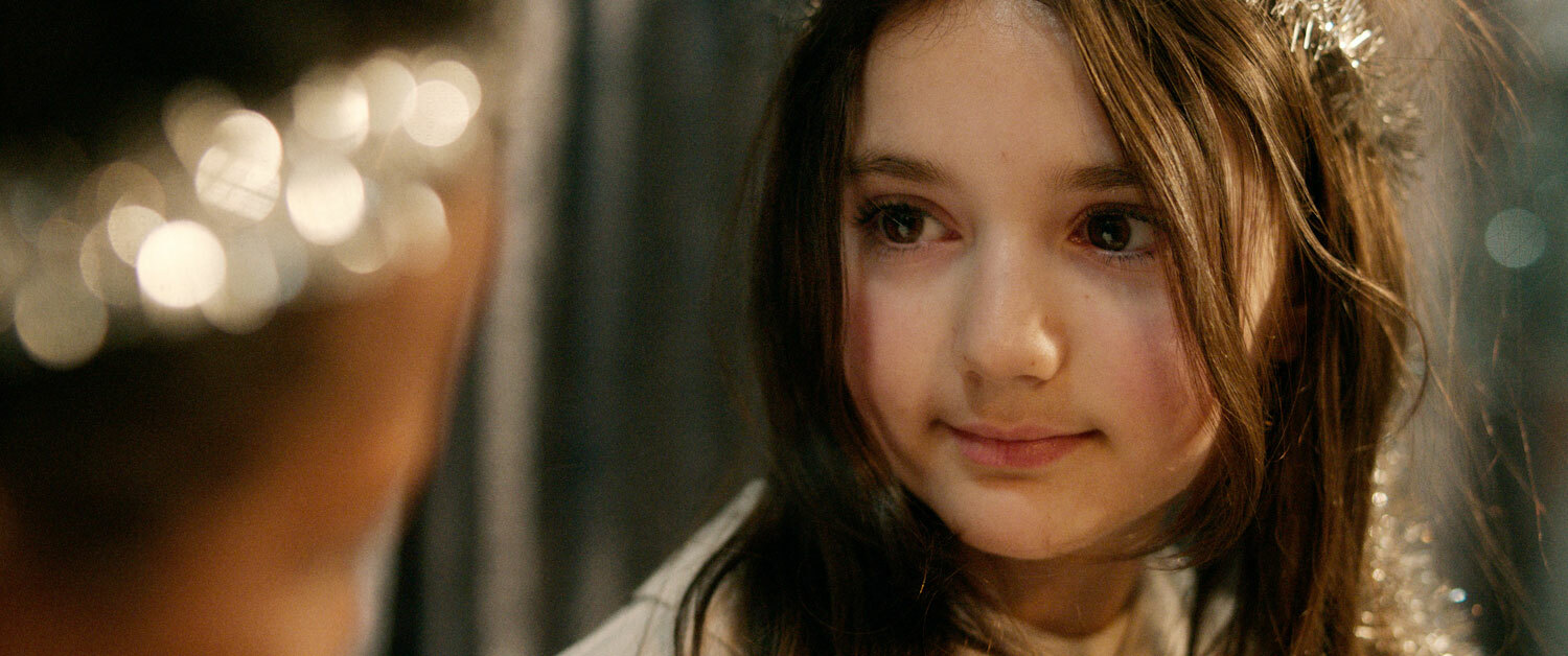 Foto: Bilde fra filmen med "close up" av en jente i tiårsalderen med mørkt hår og brune øyne.