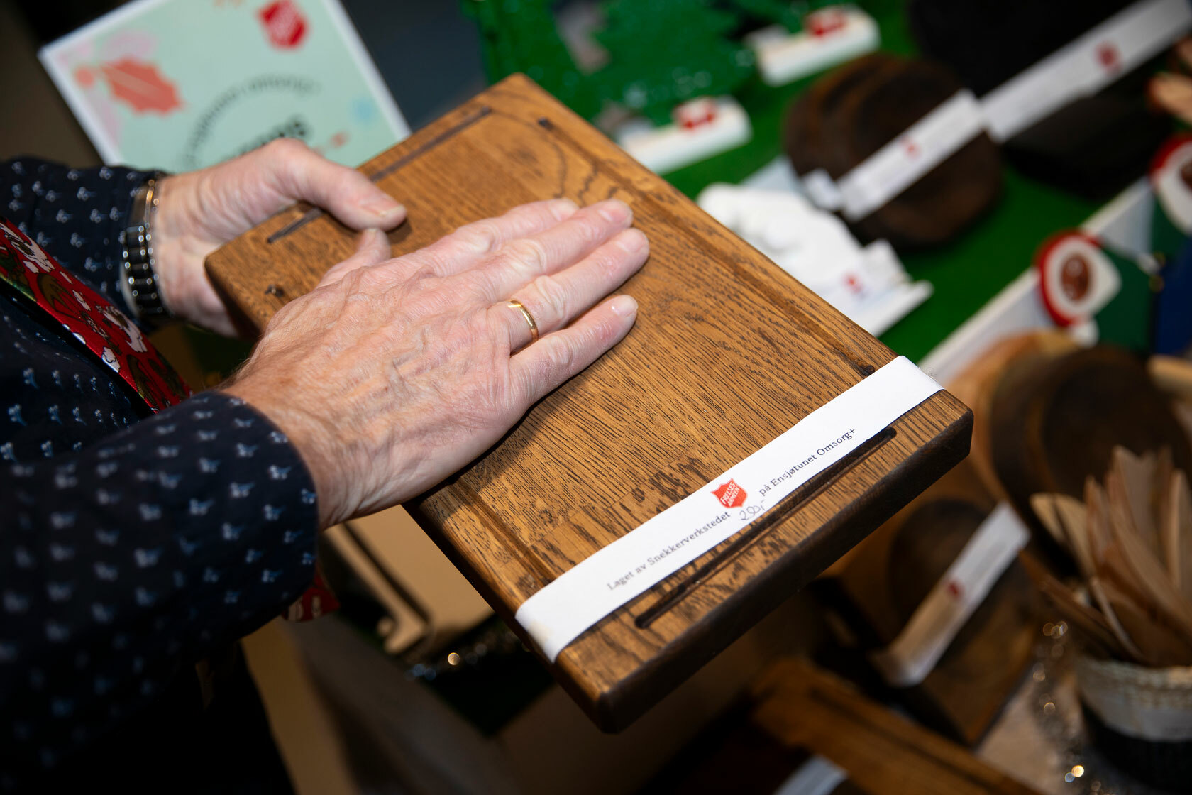 Foto: En gammel mannshånd stryker hånden over en fjøl.