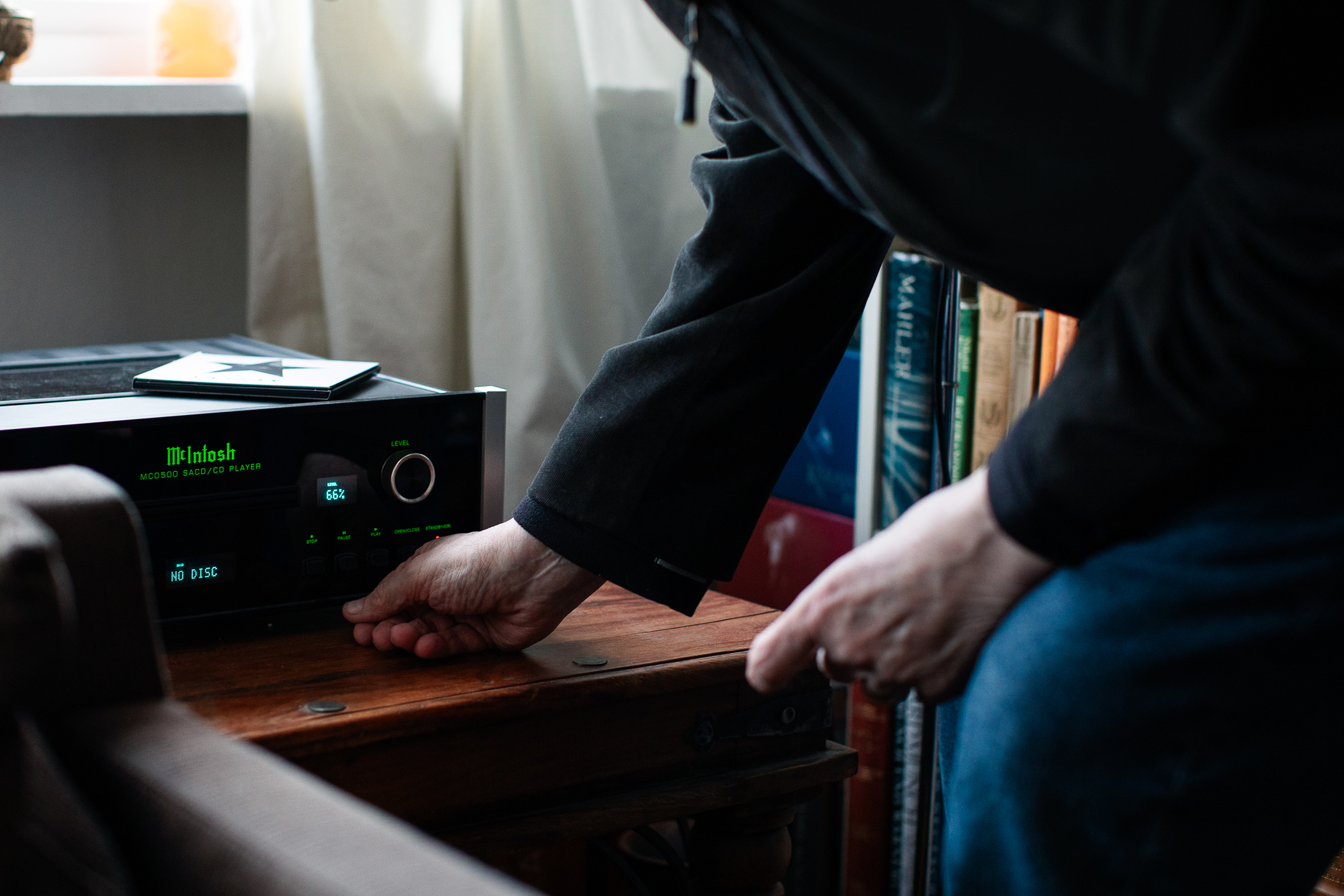 Mannshånd som skrur på stereoanlegget.