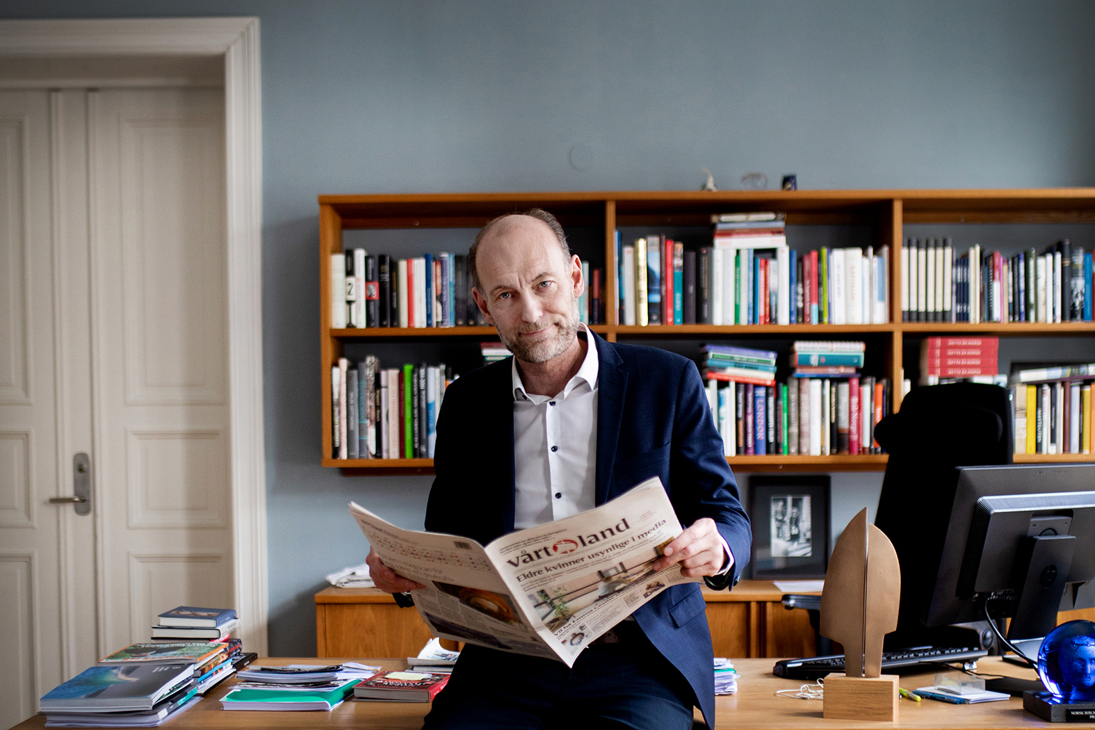 Knut Olav Åmås sitter på kontoret og leser avisen