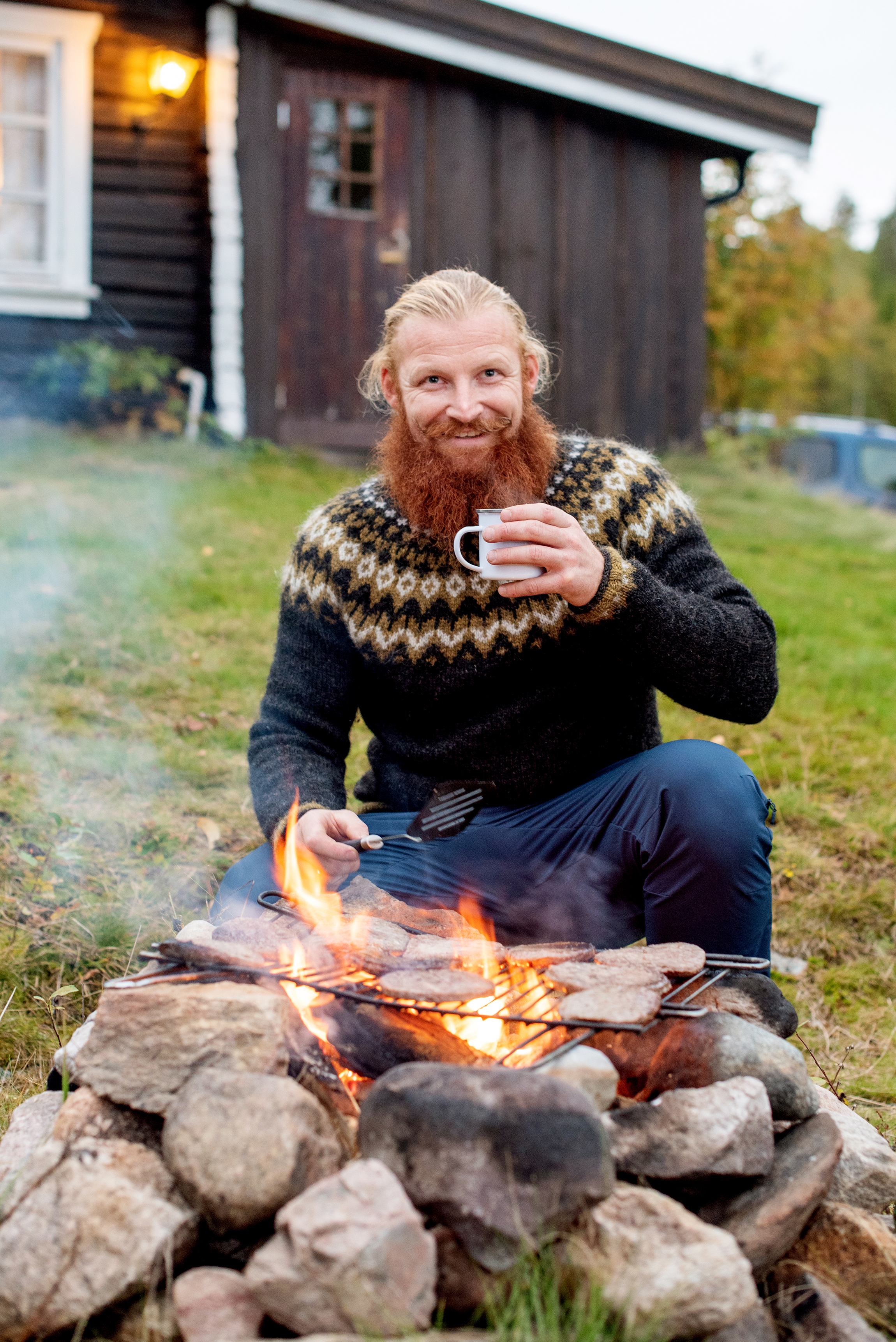 Aktivitetsleder Mats Berglund griller mat på et bål
