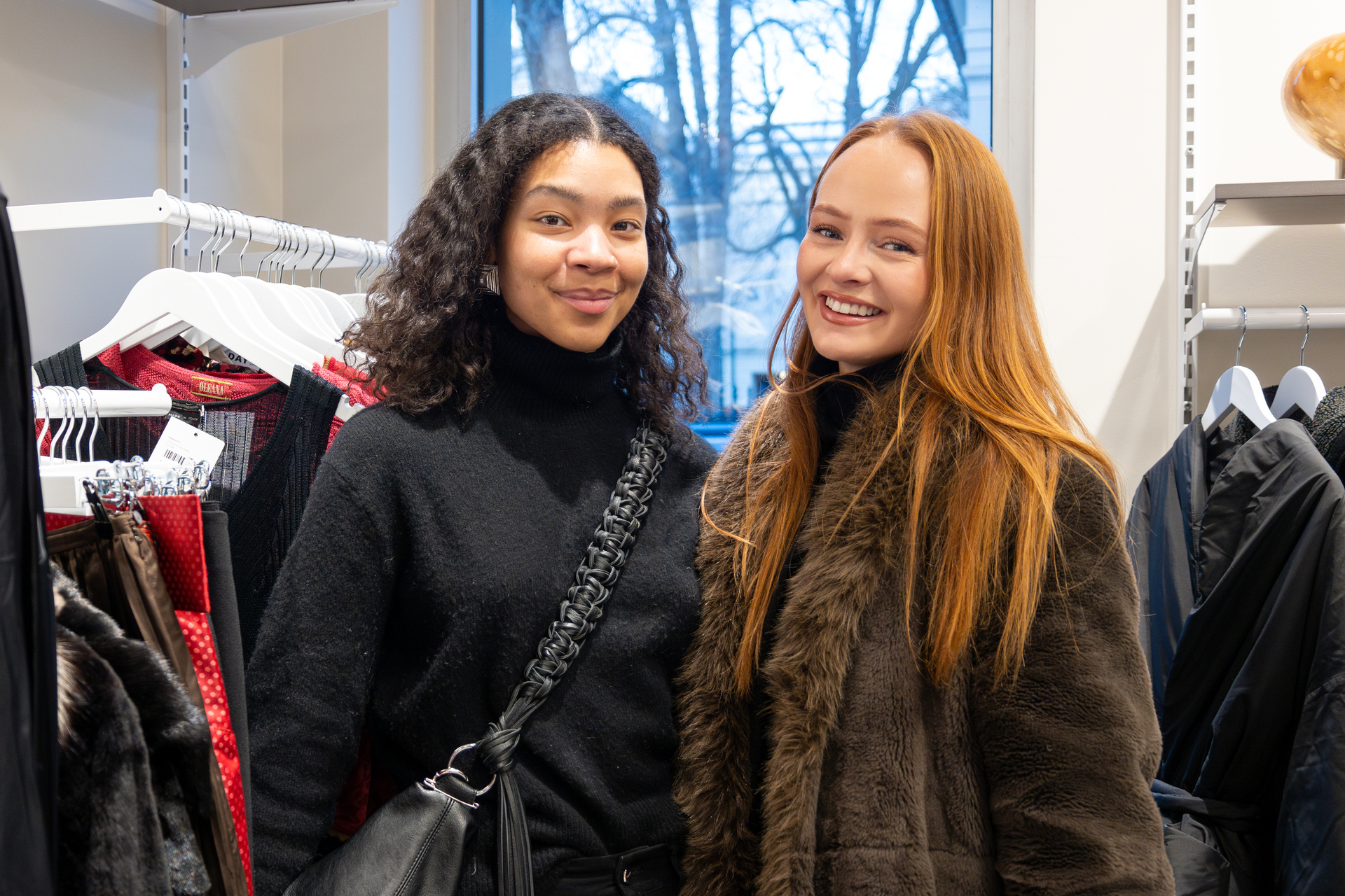 Foto: To bilder etter hverandre, der det første er av to venninner i 20-årene. Hun ene har svart hår, hun andre rødt. På det neste bildet betaler hun med rødt hår for en grå bukse. Ung dame med briller ekspederer henne.