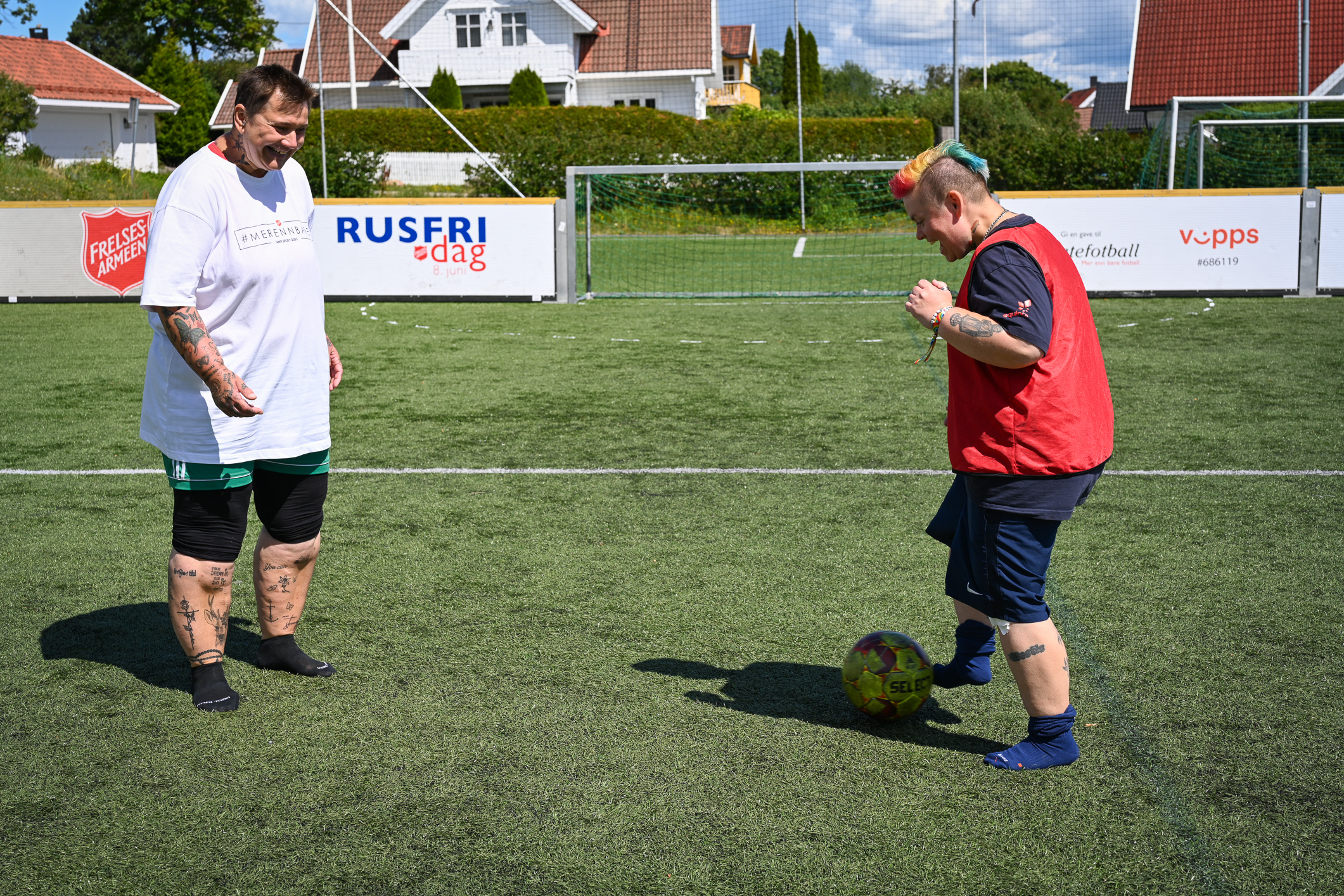 To kvinner på en fotballbane. De sparker ball mellom seg.