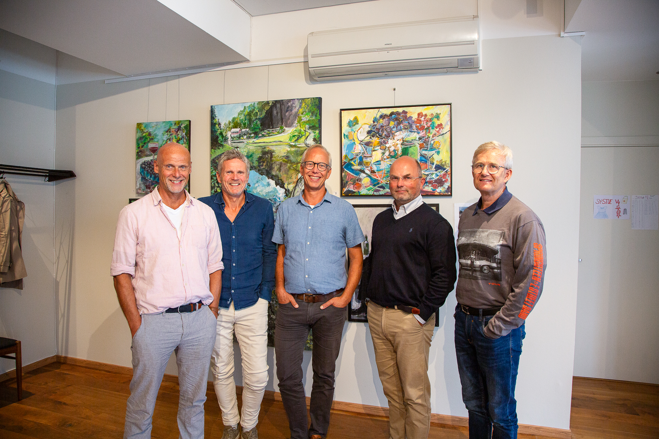 Voksne menn står bortover på rekke.