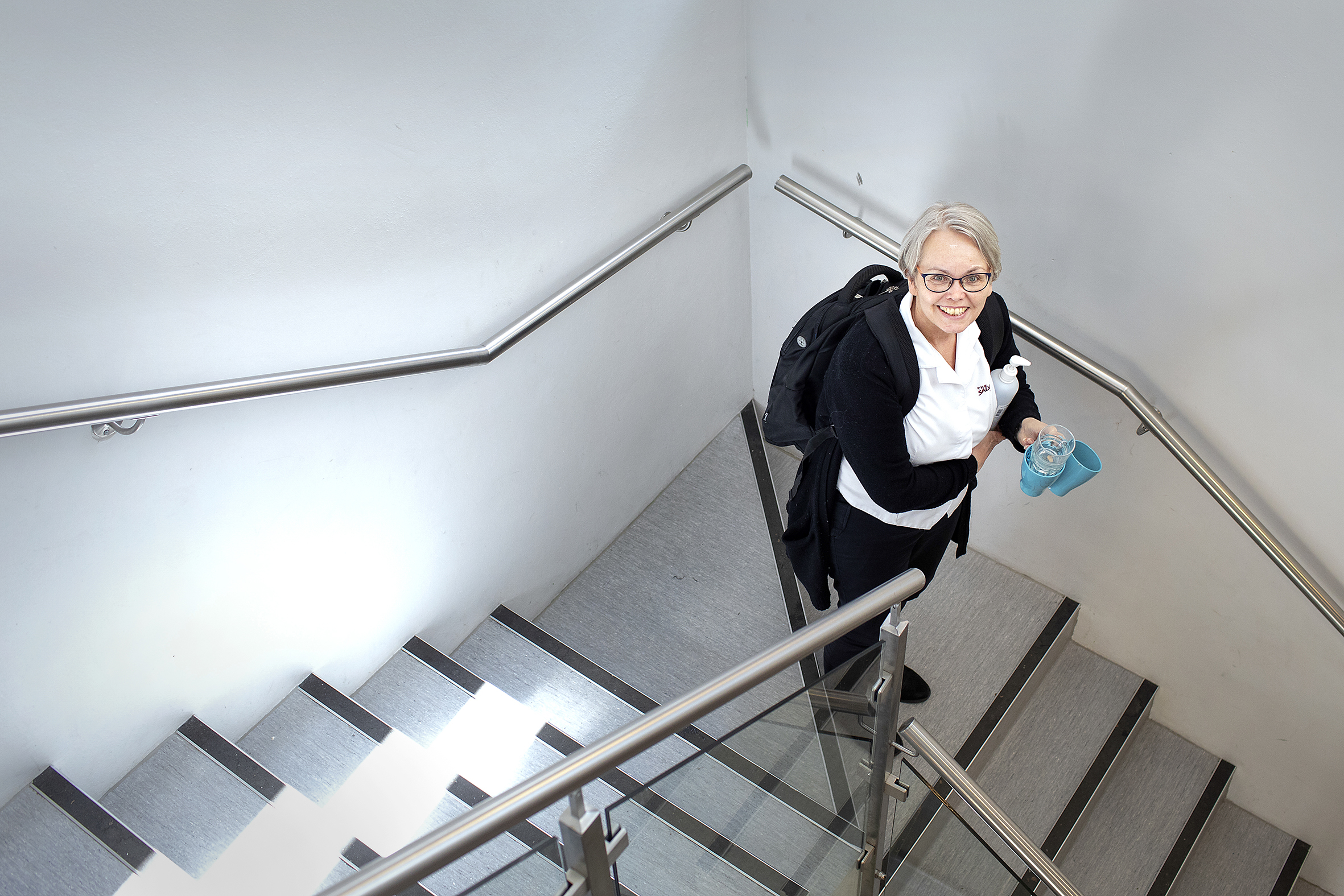 Bildet viser Saue Marti i en trapp. Hun står litt nede i trappen og ser oppover.