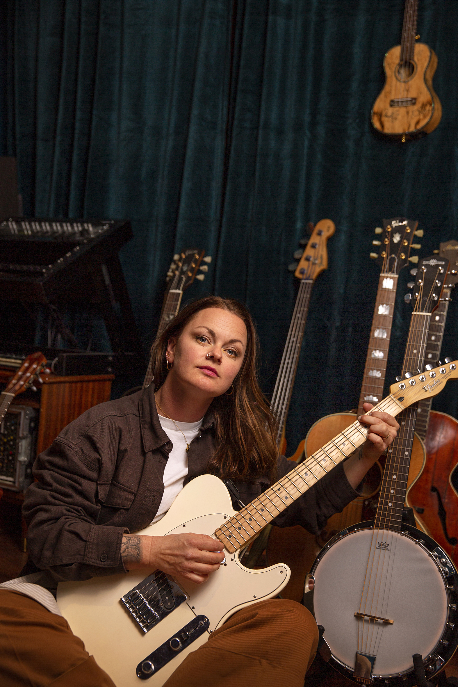 Marianne Sveen sitter i studio med gitaren i fanget