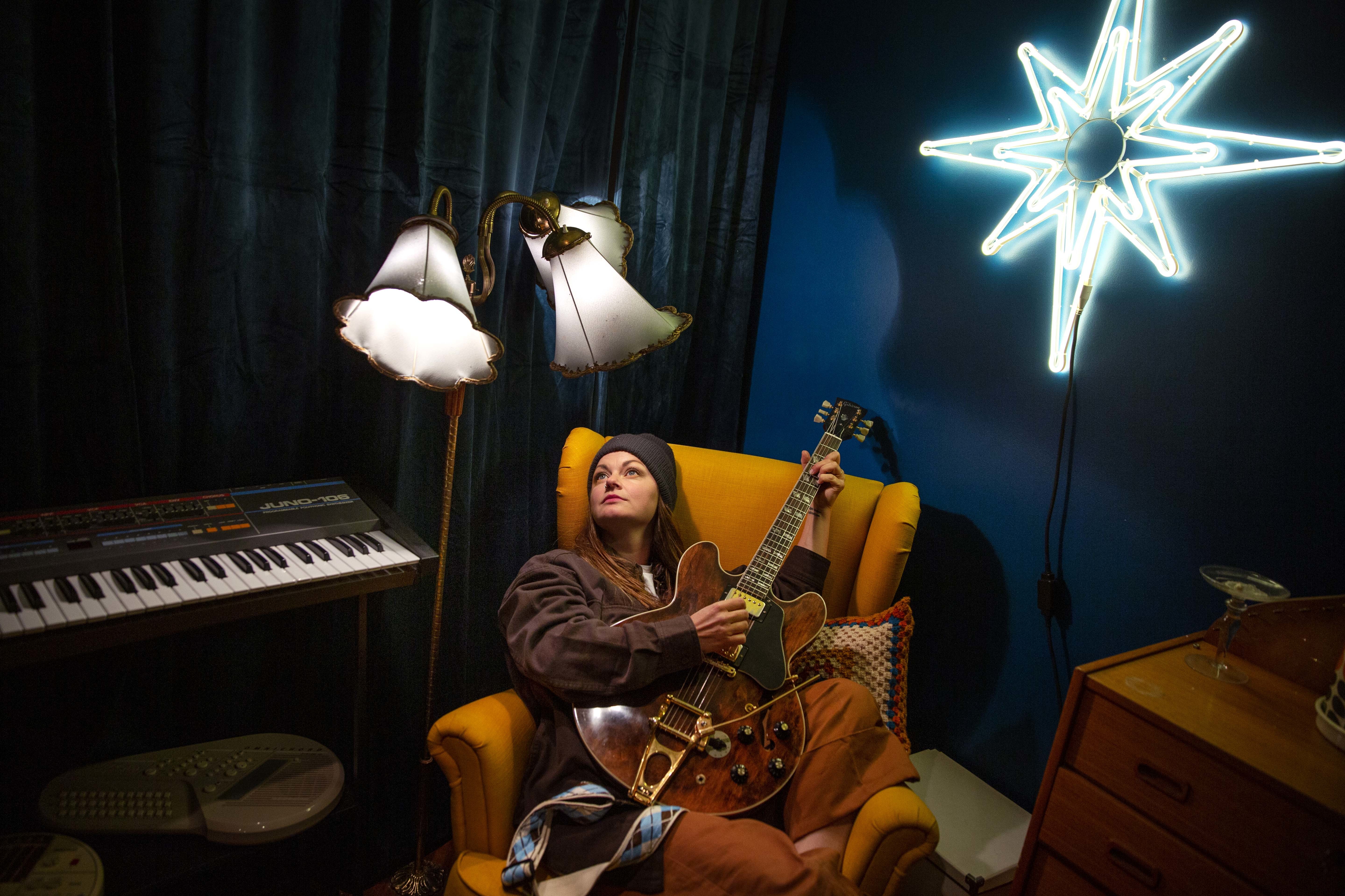 Marianne Sveen sitter i studio med gitaren