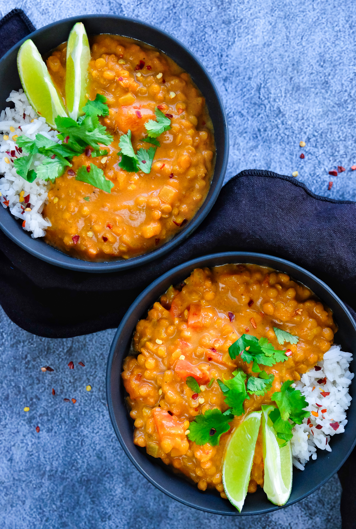 Foto: To boller med ris og rød linsegryte – pyntet med limebåter og koriander.