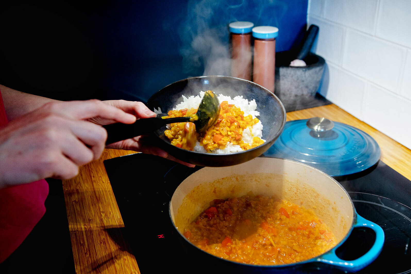 To foto ved siden av hverandre, der det første viser ung kvinne som står ved gryta og smaker på maten. Det andre er et nærbilde av maten, som er ris og rød linsegryte.