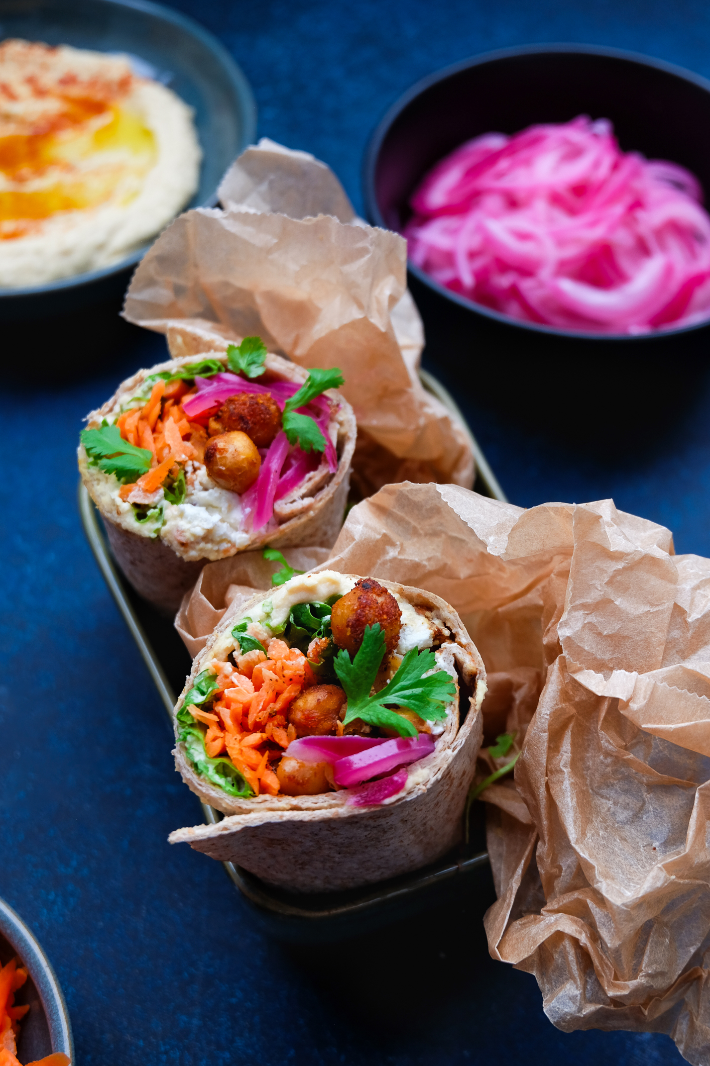 Foto: Nærbilde av wraps med stekte kikerter, hummus, gulrot, koriander og rødløk.