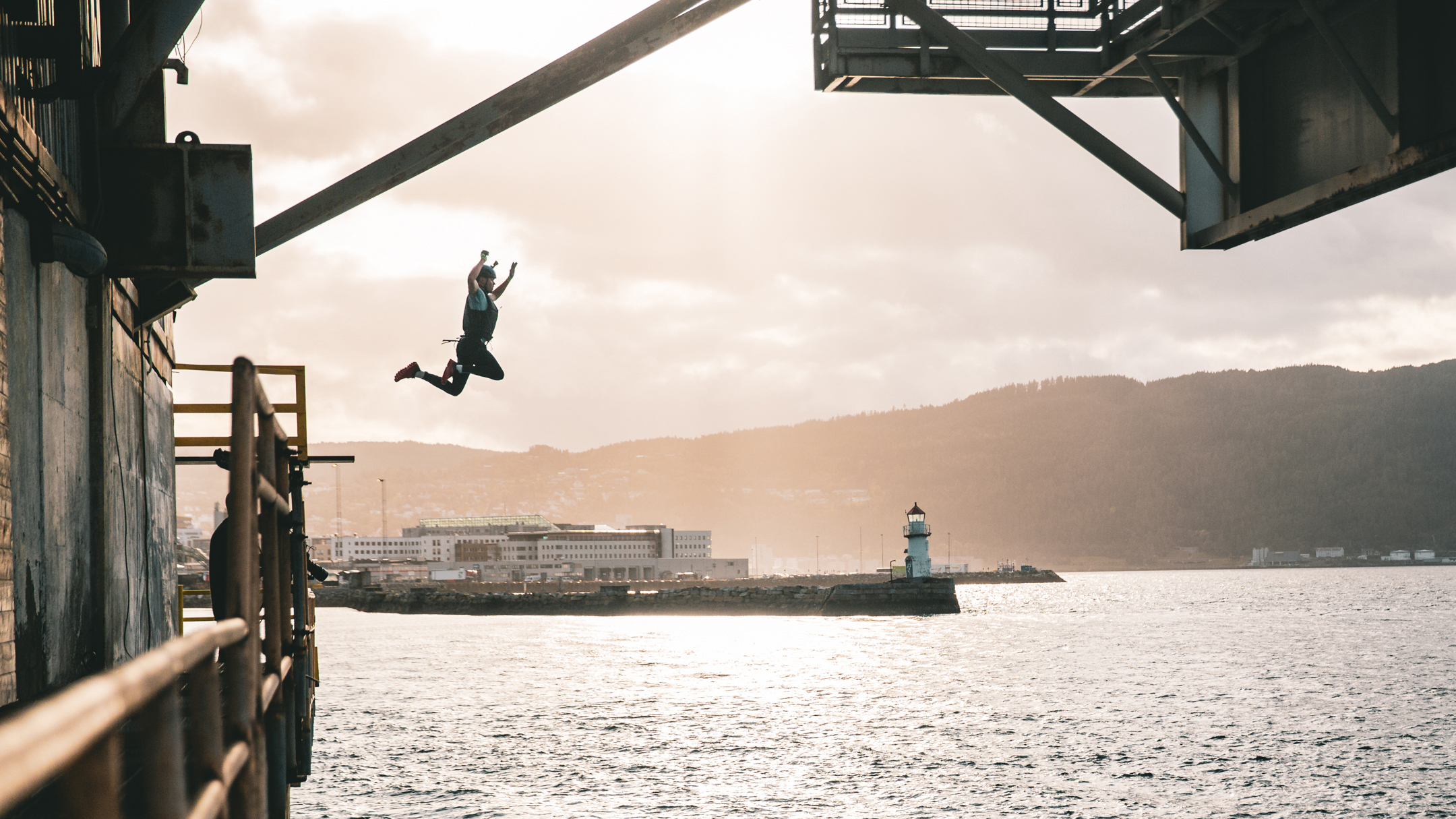 I Norges tøffeste måtte Martin hoppe fra et tak og ned i vannet (bilde t.h) og klatre opp en høy silo (bilde t.v)