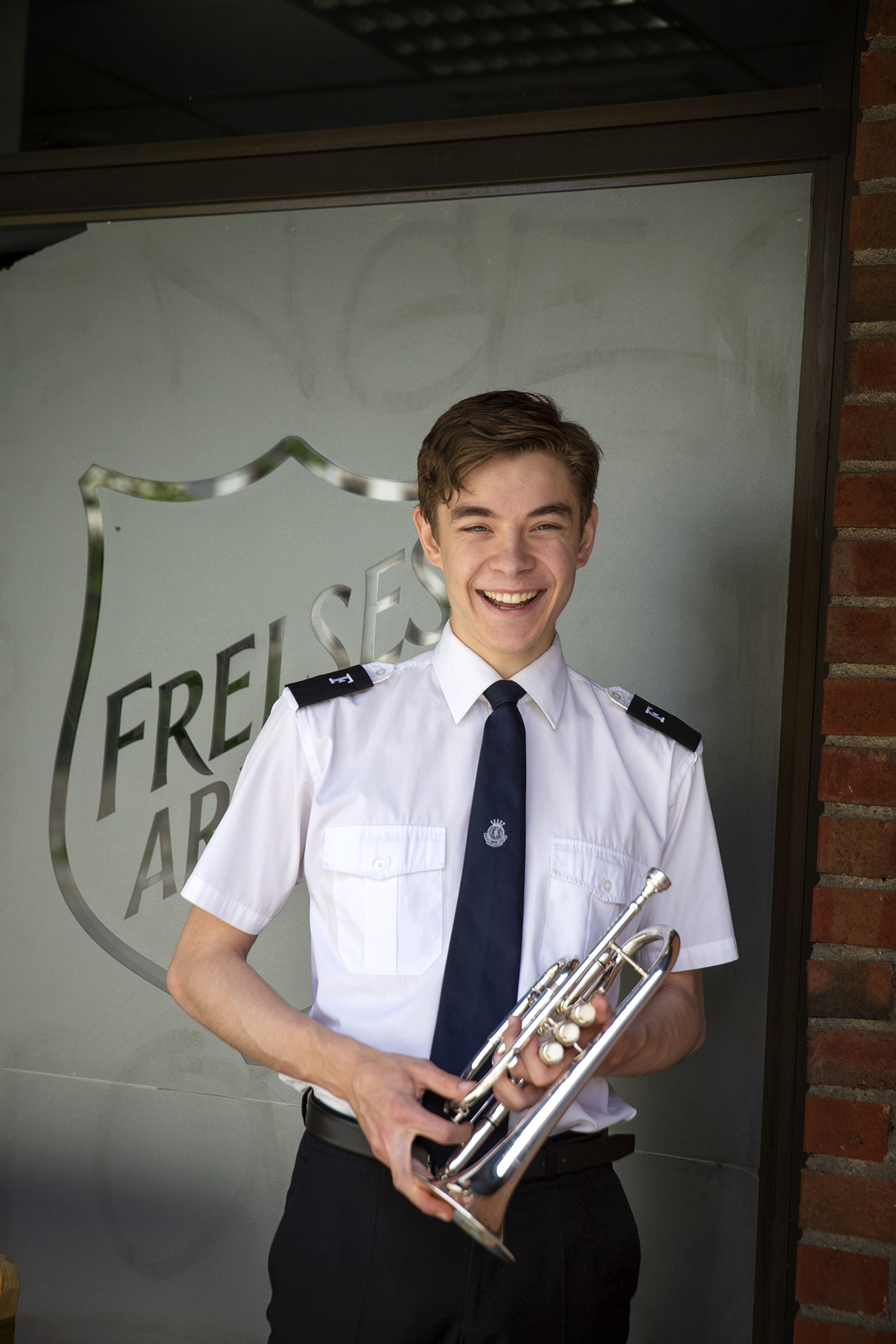 Mattias Milde Amland står i uniform utenfor Tempelet i Oslo, og holder i kornetten sin