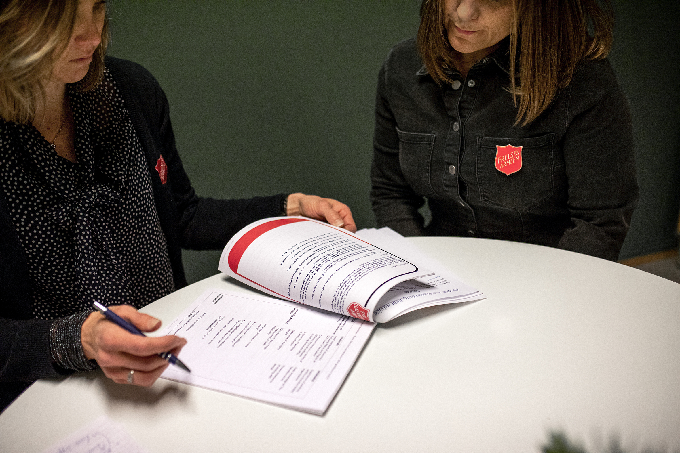 Katrine Hogganvik og Kristin Stordal sitter ved et bord og ser på rapporter fra prosjektet