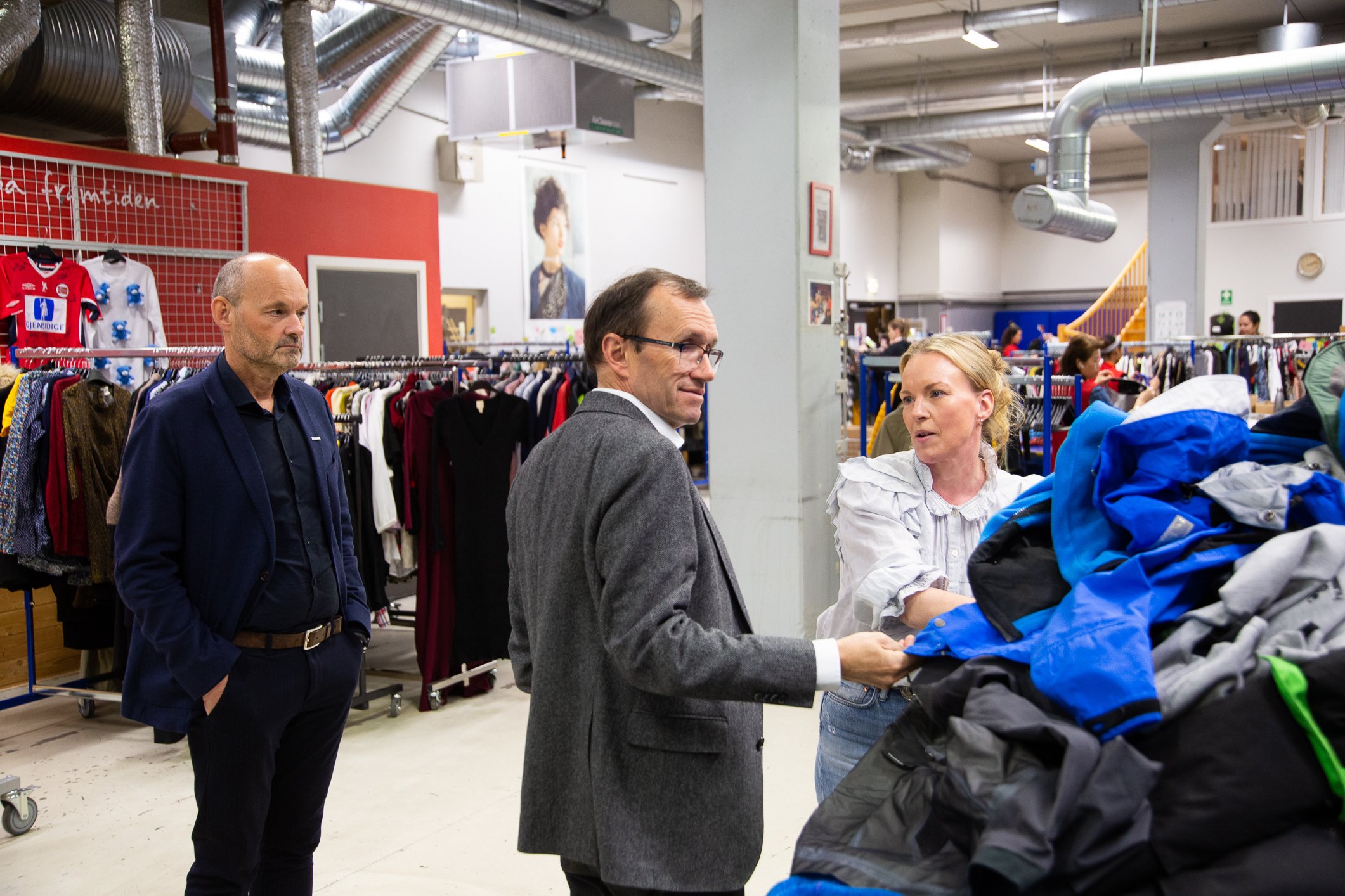 Espen Barth Eide står sammen med Hilde Kjønstad og ser på klær som er sortert for videresalg i Fretex butikkene.