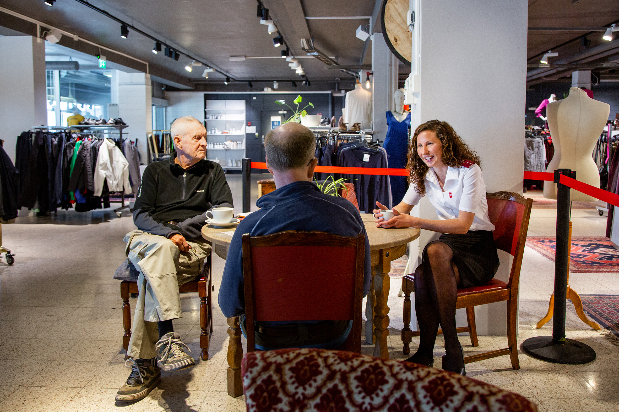 Monica drikker kaffe sammen med to  menn