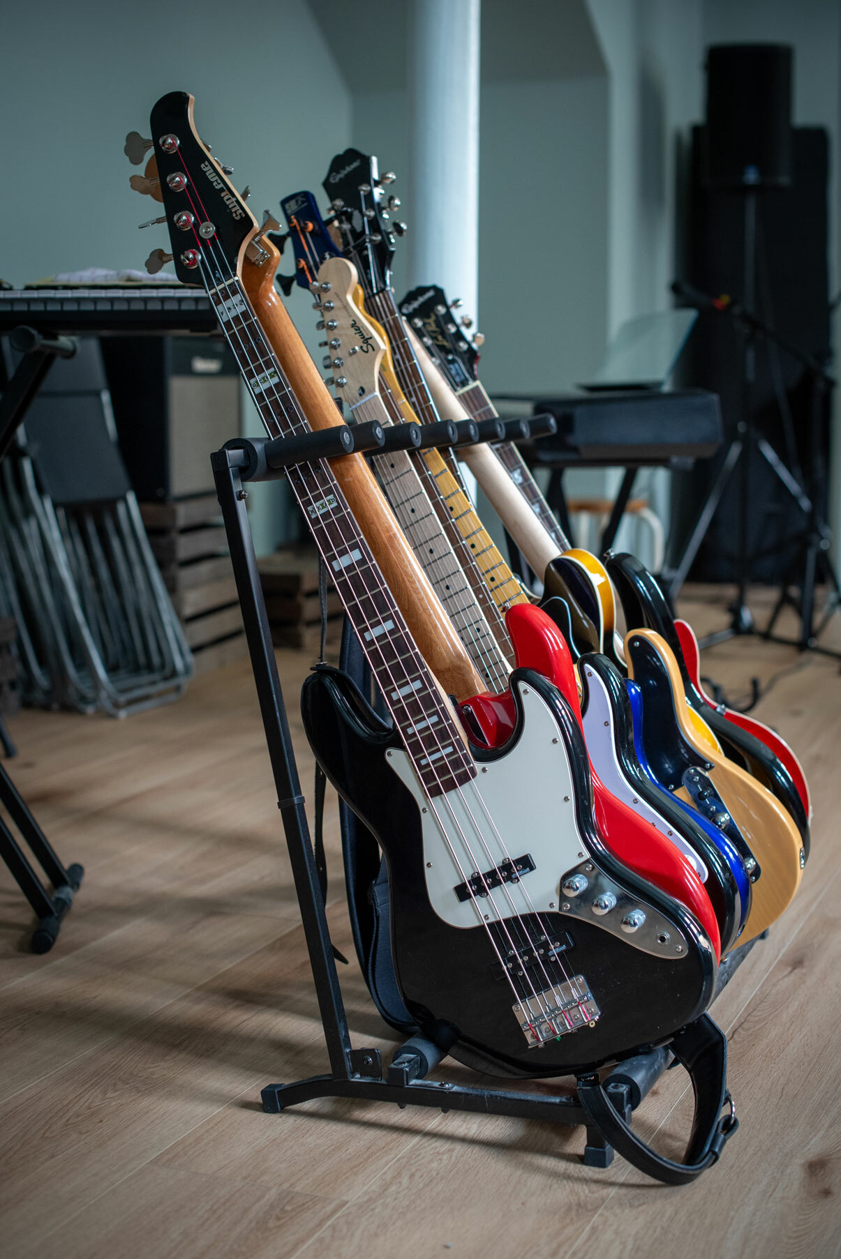 Foto: En rekke elektriske gitarer står i et stativ i et rom.
