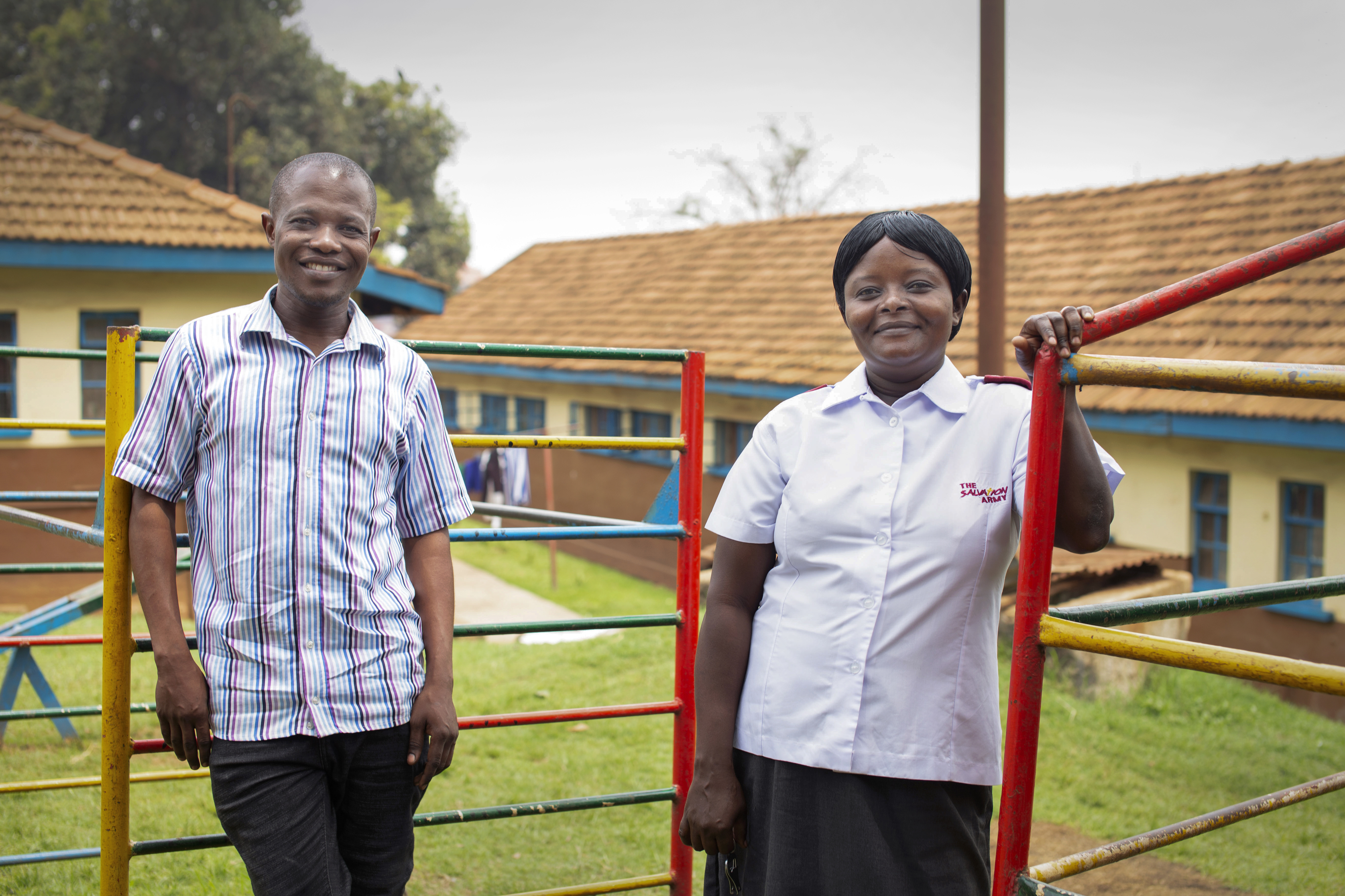 Bildet viser moses og Gorret som står utendørs foran barnehjemmet og smiler mot kamera.