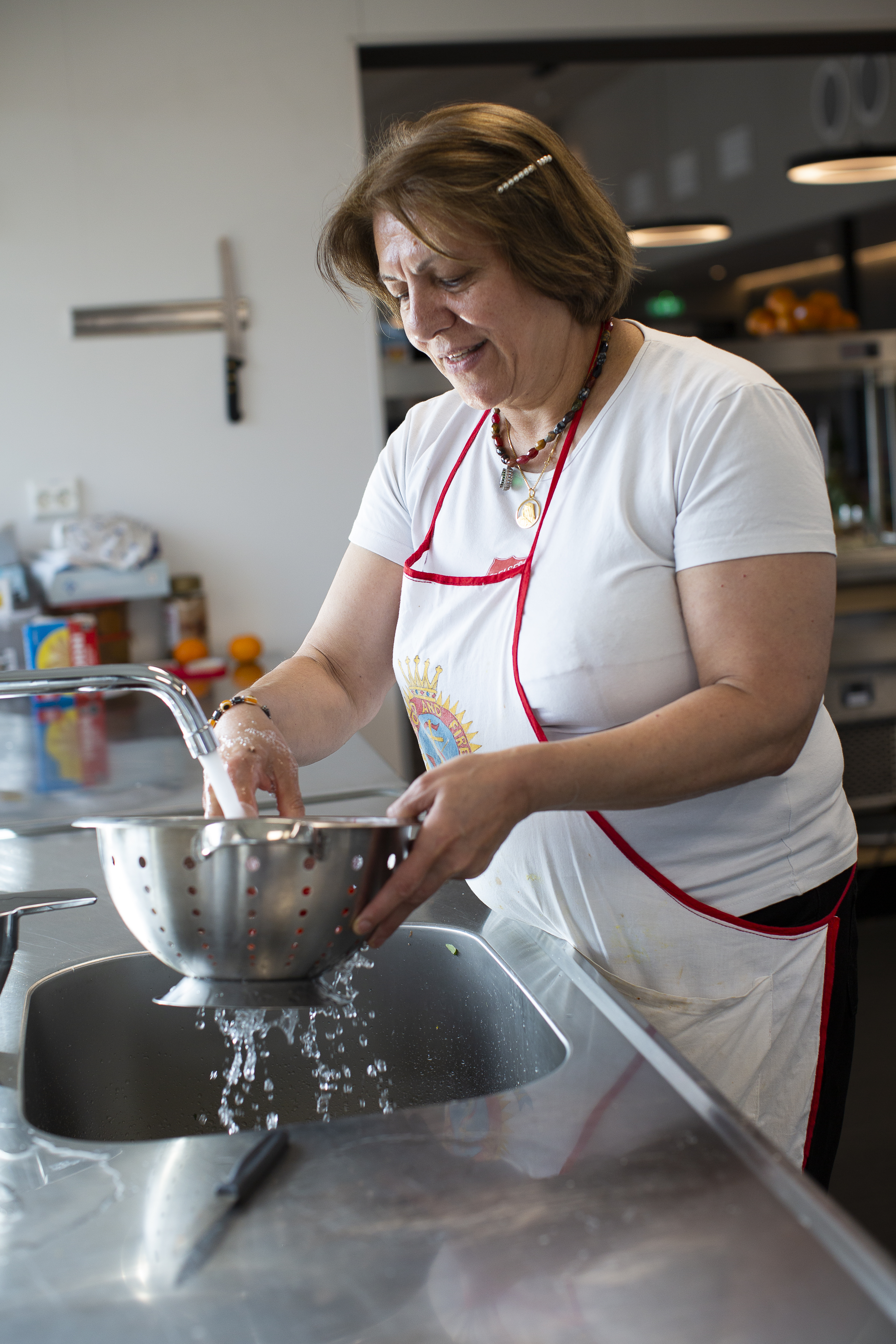 Fatemeh i soldatuniform foran Frelsesarmeens flagg. På bilde to står hun og vasker opp på kjøkkenet hos Frelsesarmeen i Kristiansand.