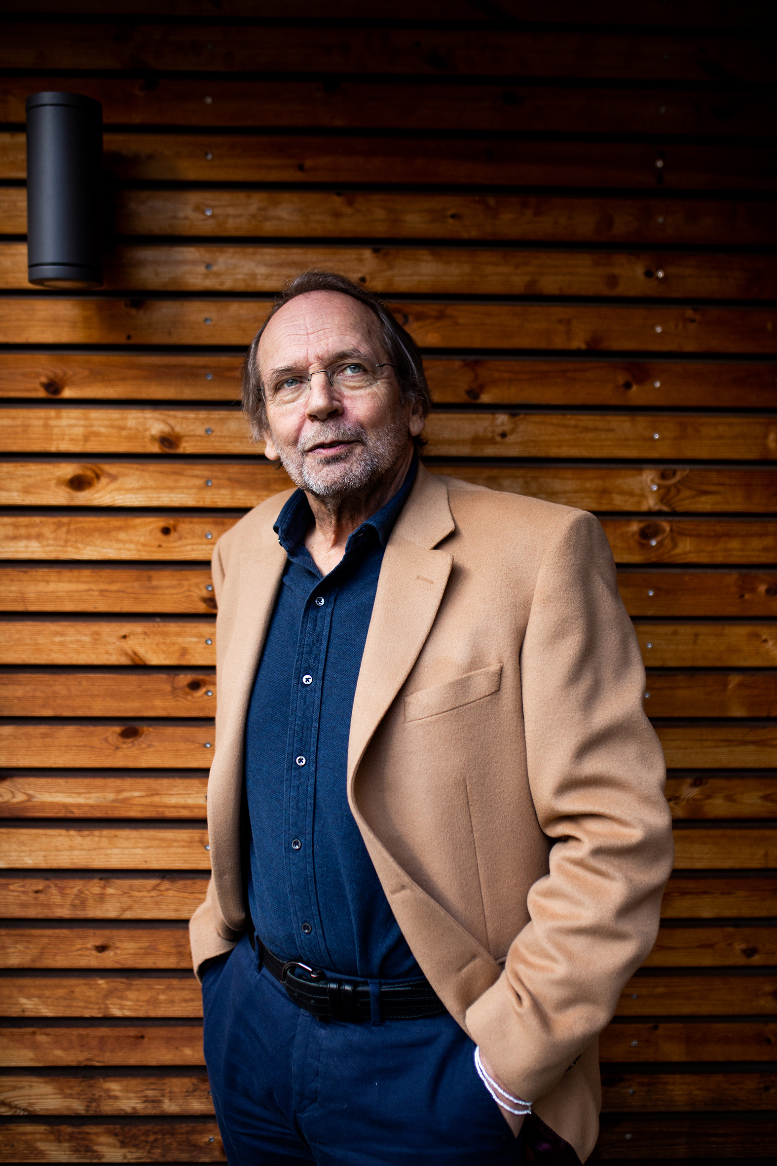 Ole paus sitter i sin egen stue og spiller på gitar (bilde t. v.). Ole Paus atår ute foran en vegg (bilde t.h)