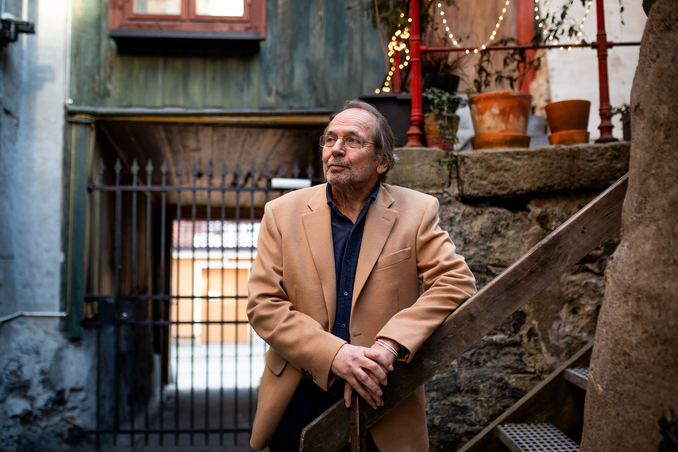 Ole Paus står ute og lener seg til en trapp