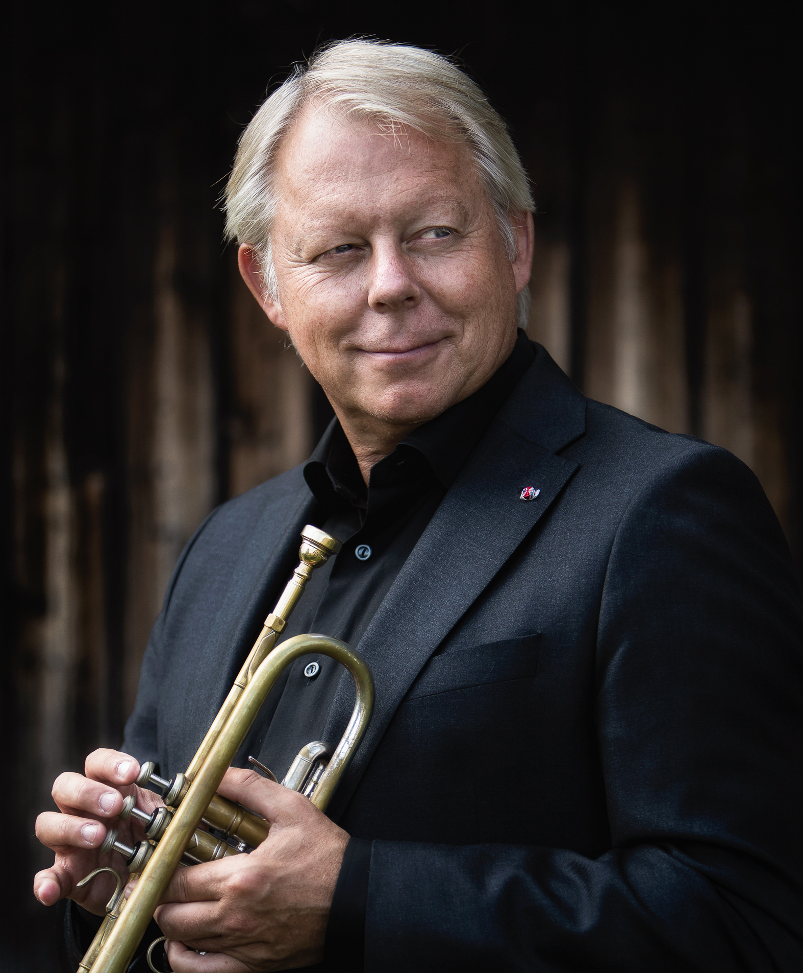 Godt voksen mann med trompet i hendene.