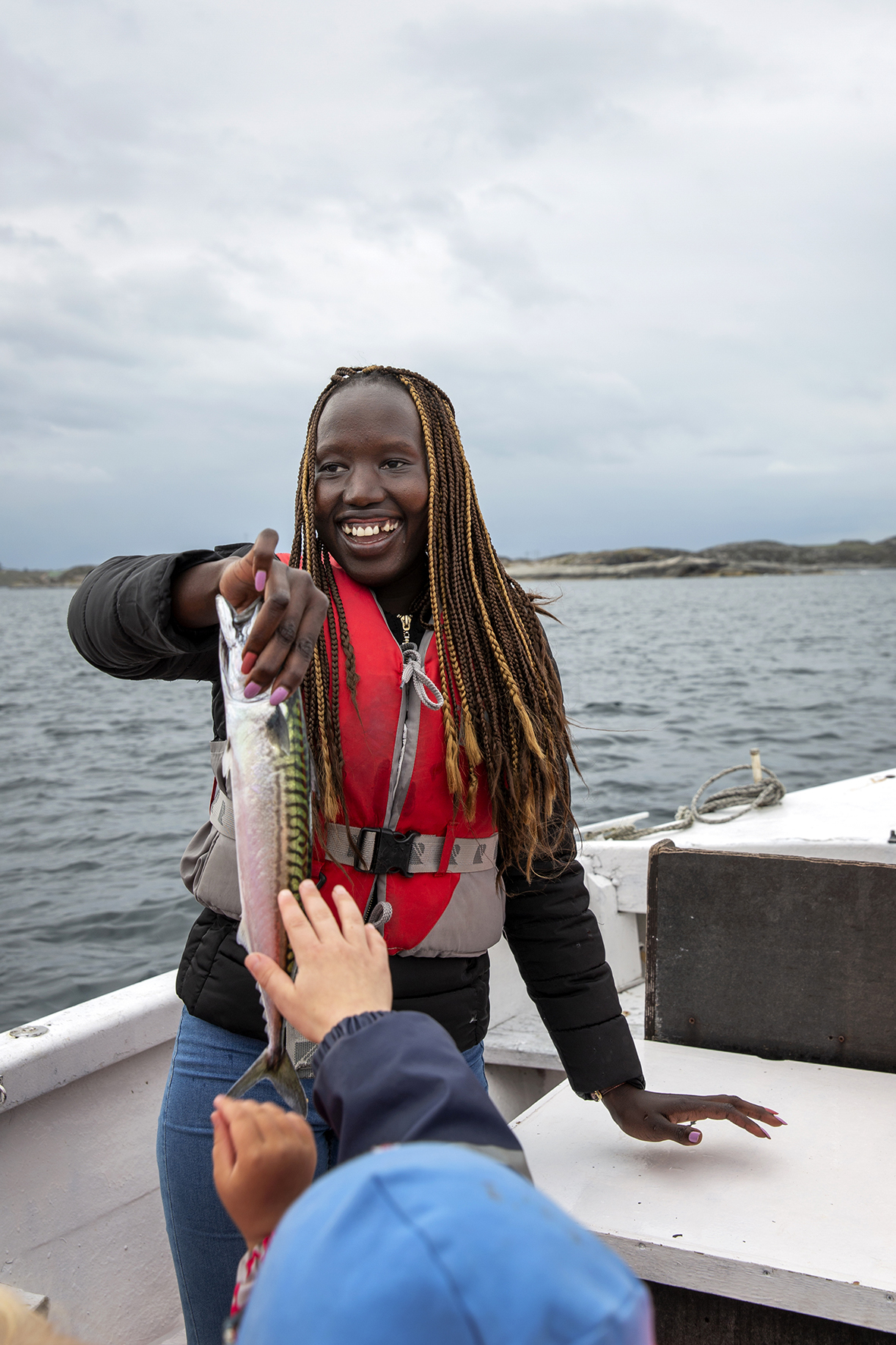 En stolt jente har fått fisk og en liten gutt henger i en zip-line