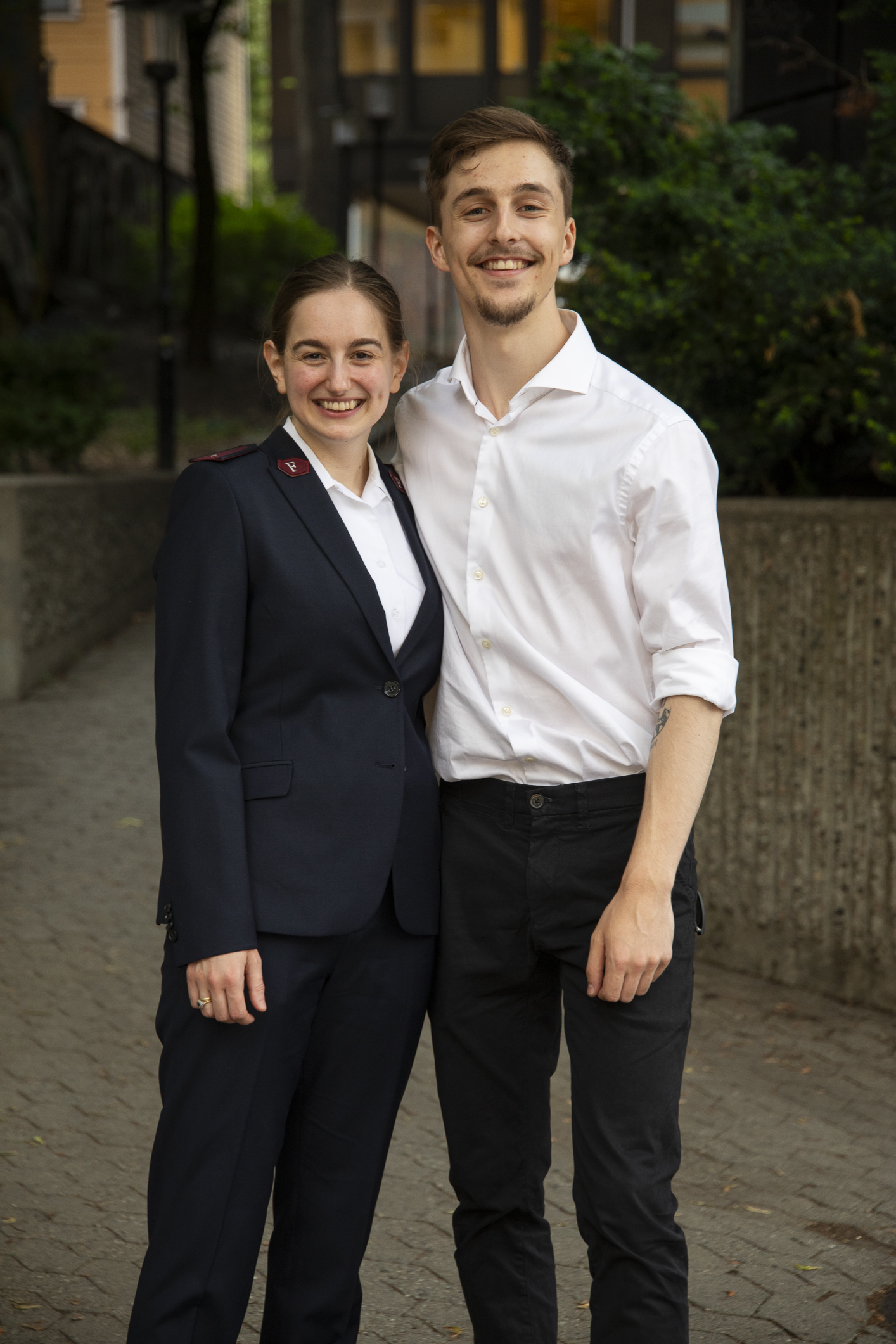 Ungt par holder rundt hverandre og smiler i kamera.