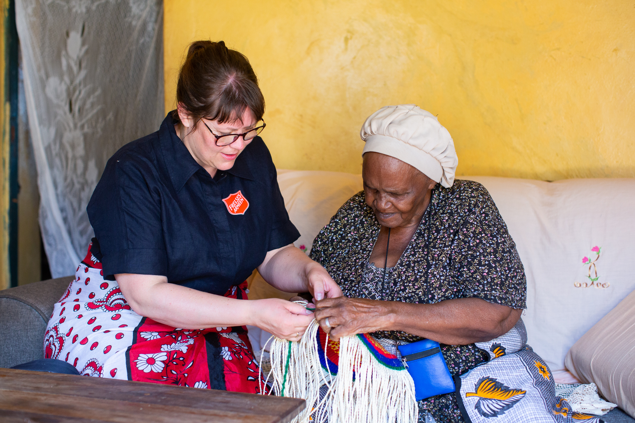 De to kvinnene Stine Tybrig Aune og Agnes sitter og ser på håndverk