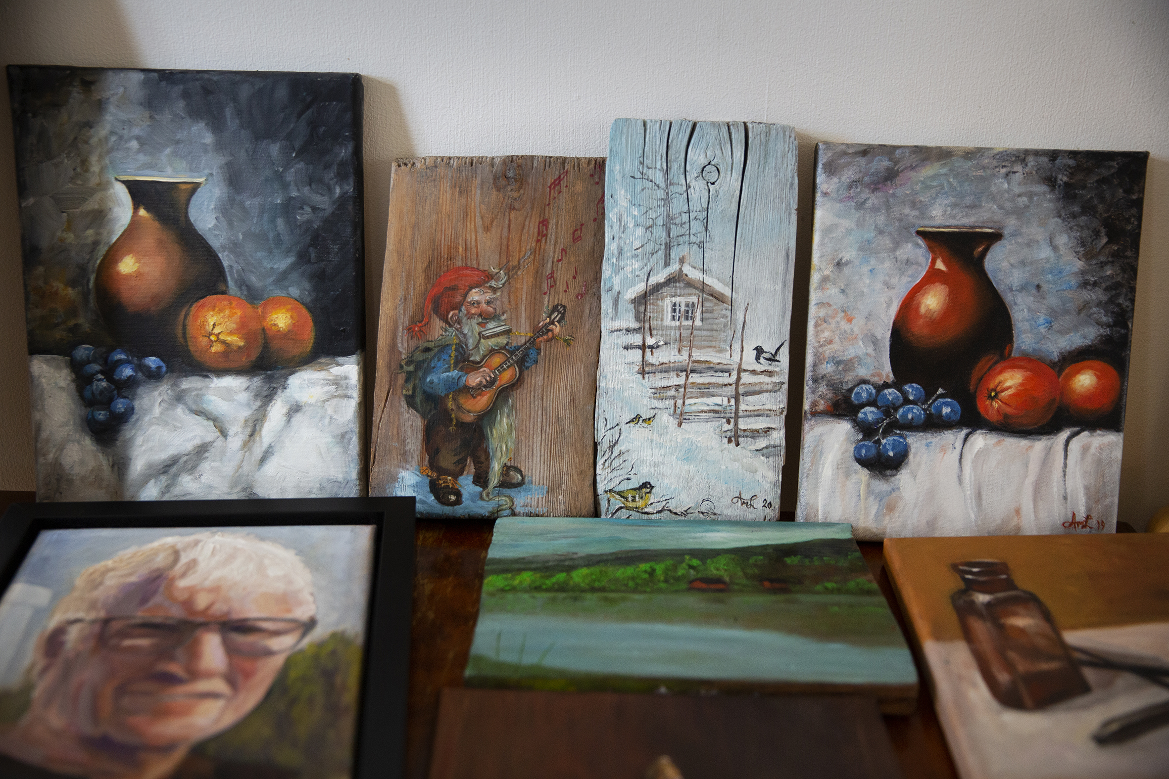 Bildet til venstre er et nærbilde av en hånd som holder et godt brukt palett. Bildet til høyre viser flere av kunstverkene som har blitt skapt på Ensjøtunet.