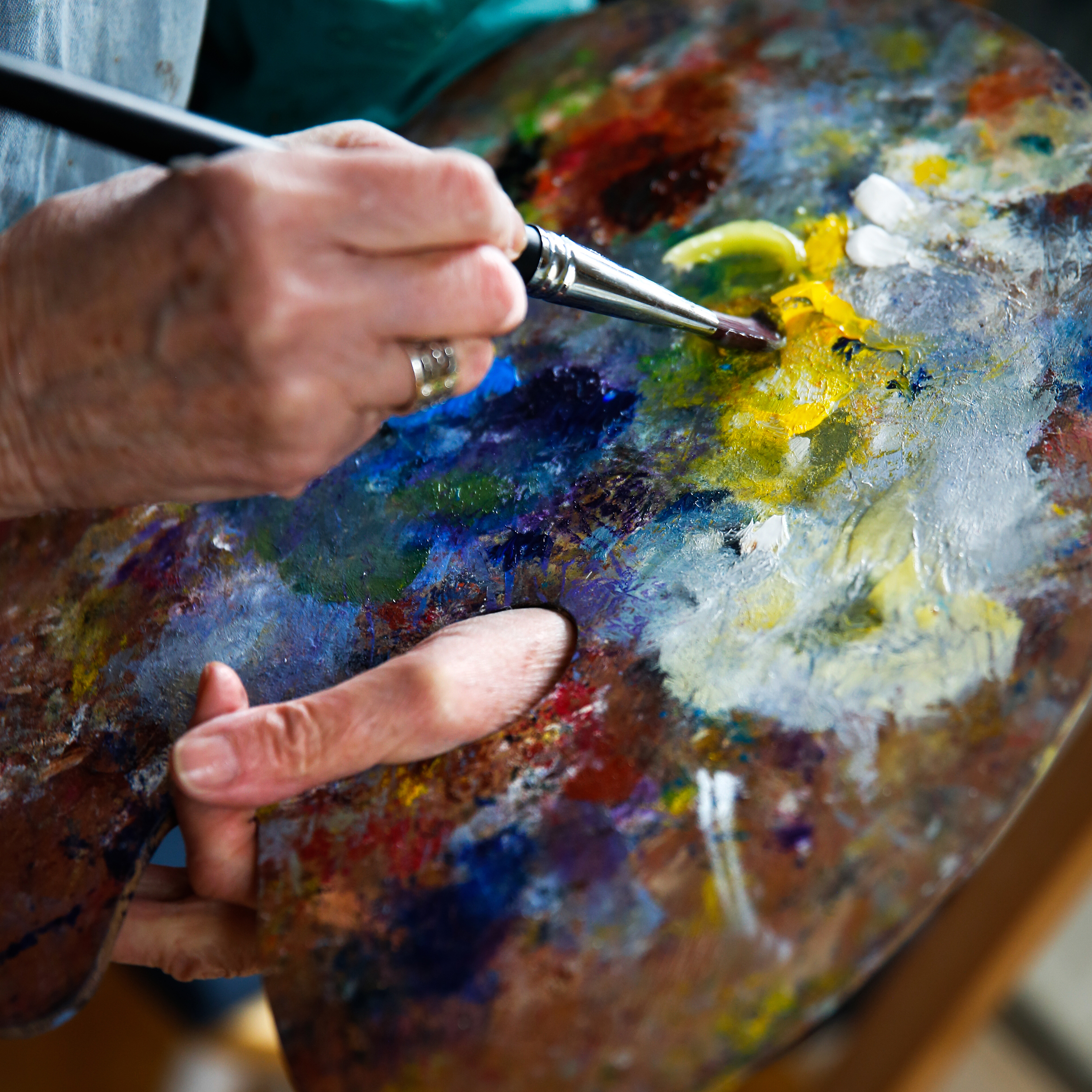 Bildet til venstre er et nærbilde av en hånd som holder et godt brukt palett. Bildet til høyre viser flere av kunstverkene som har blitt skapt på Ensjøtunet.