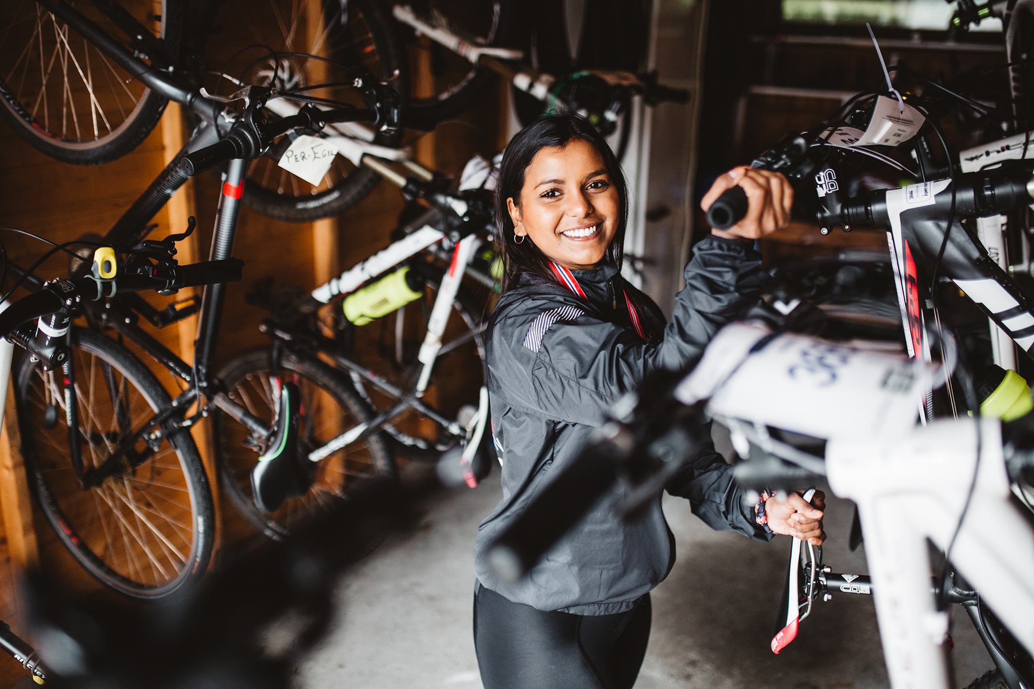 Jente som holder en sykkel (bilde t.v.) Syklister som trener til sommerens ritt (bilde t.h.)