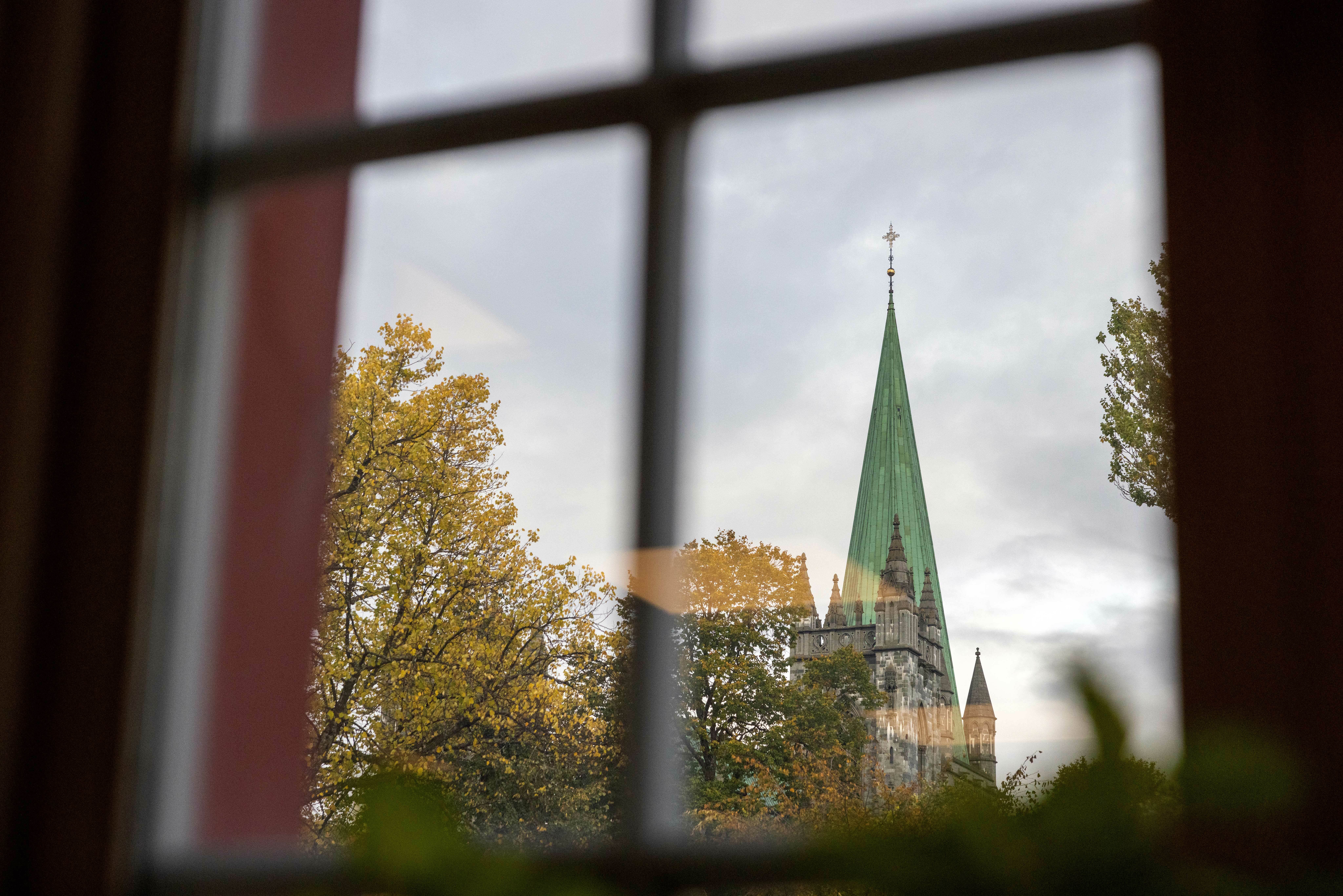 Gjennom et rutete vindu ser man et kirkespir.