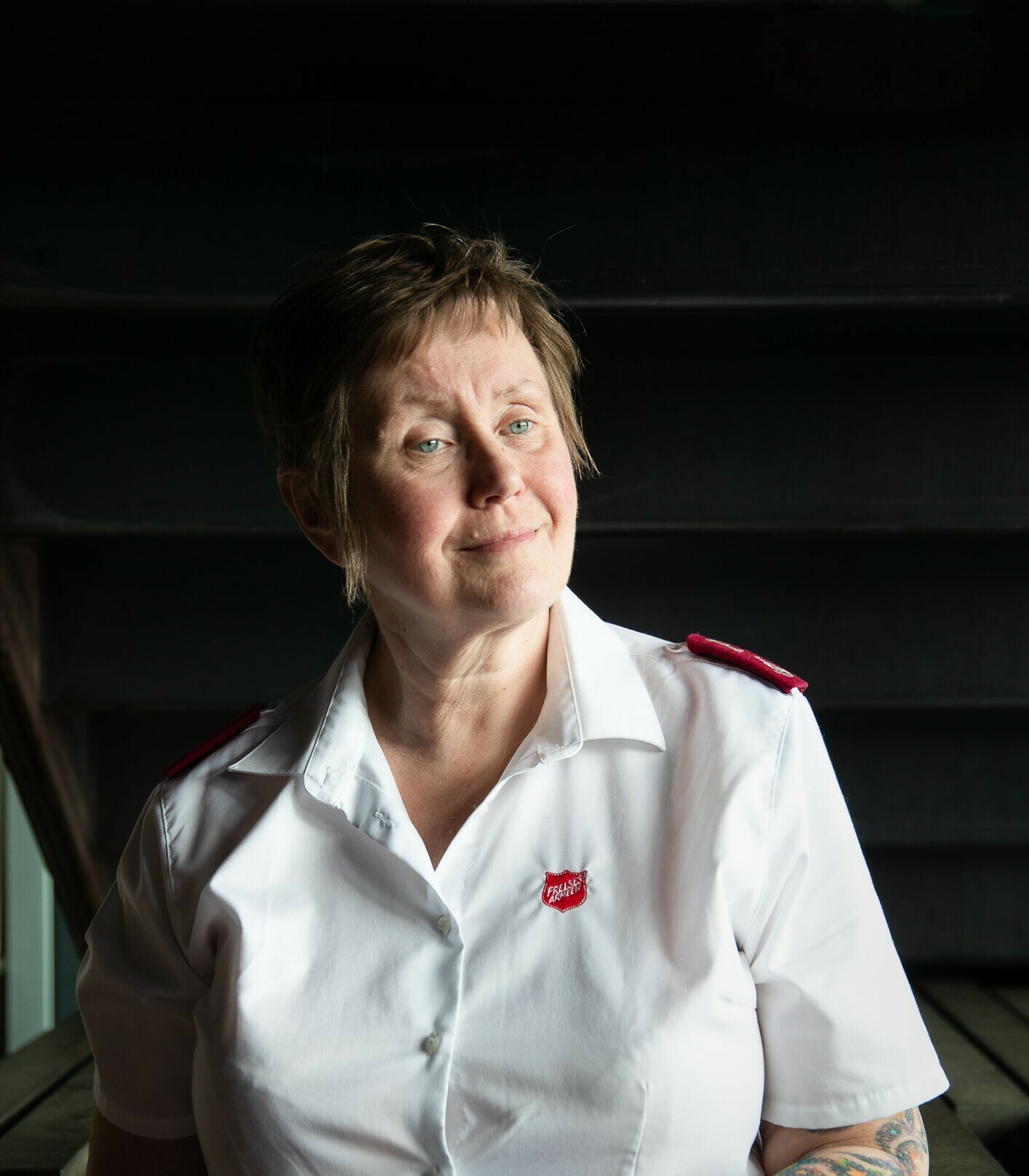 Foto: Kvinne i 60-årene i hvit uniformsskjorte fra Frelsesarmeen.