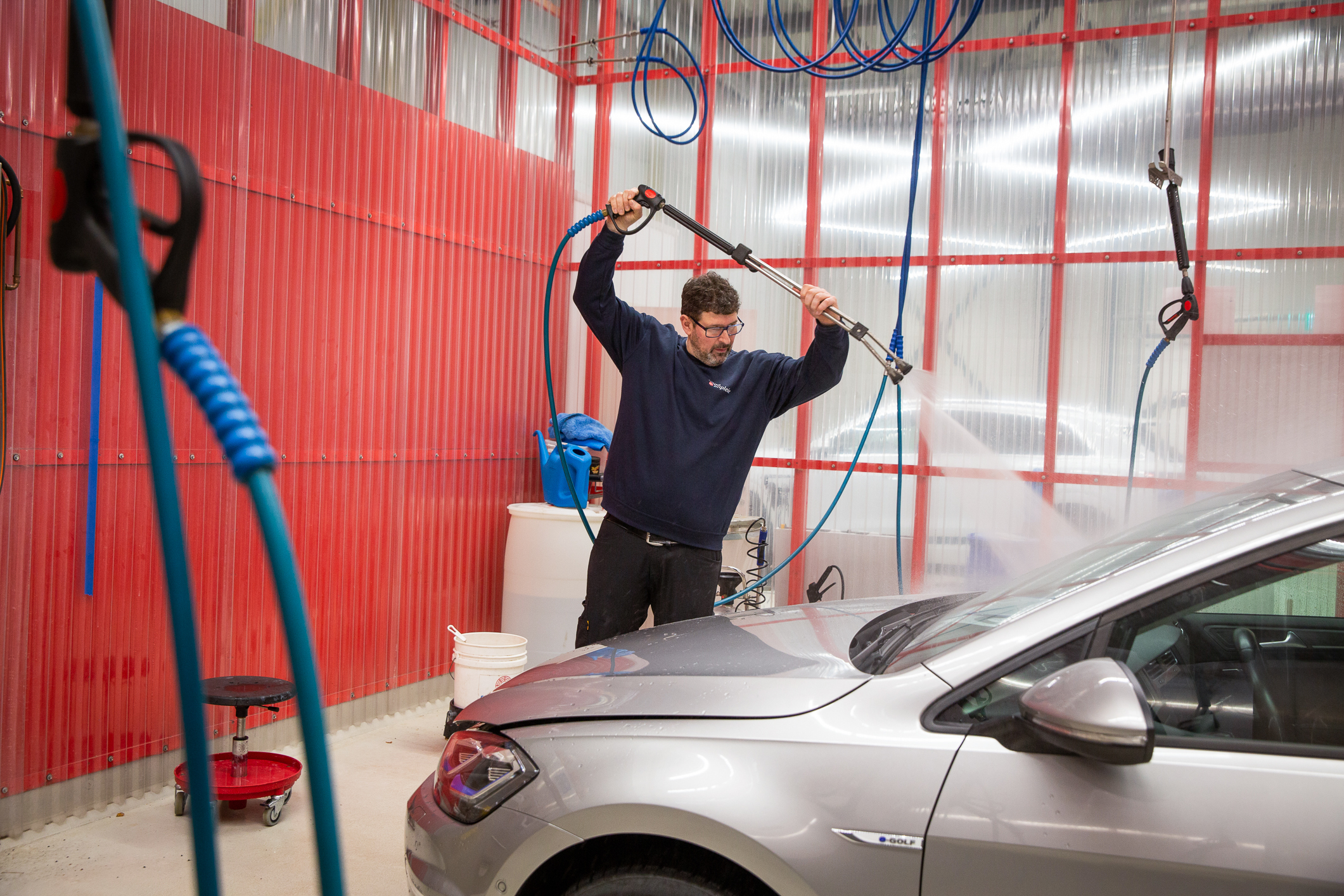 T.V.: Poul som spyler bilen. T.H.: Eske med vaskeredskaper.